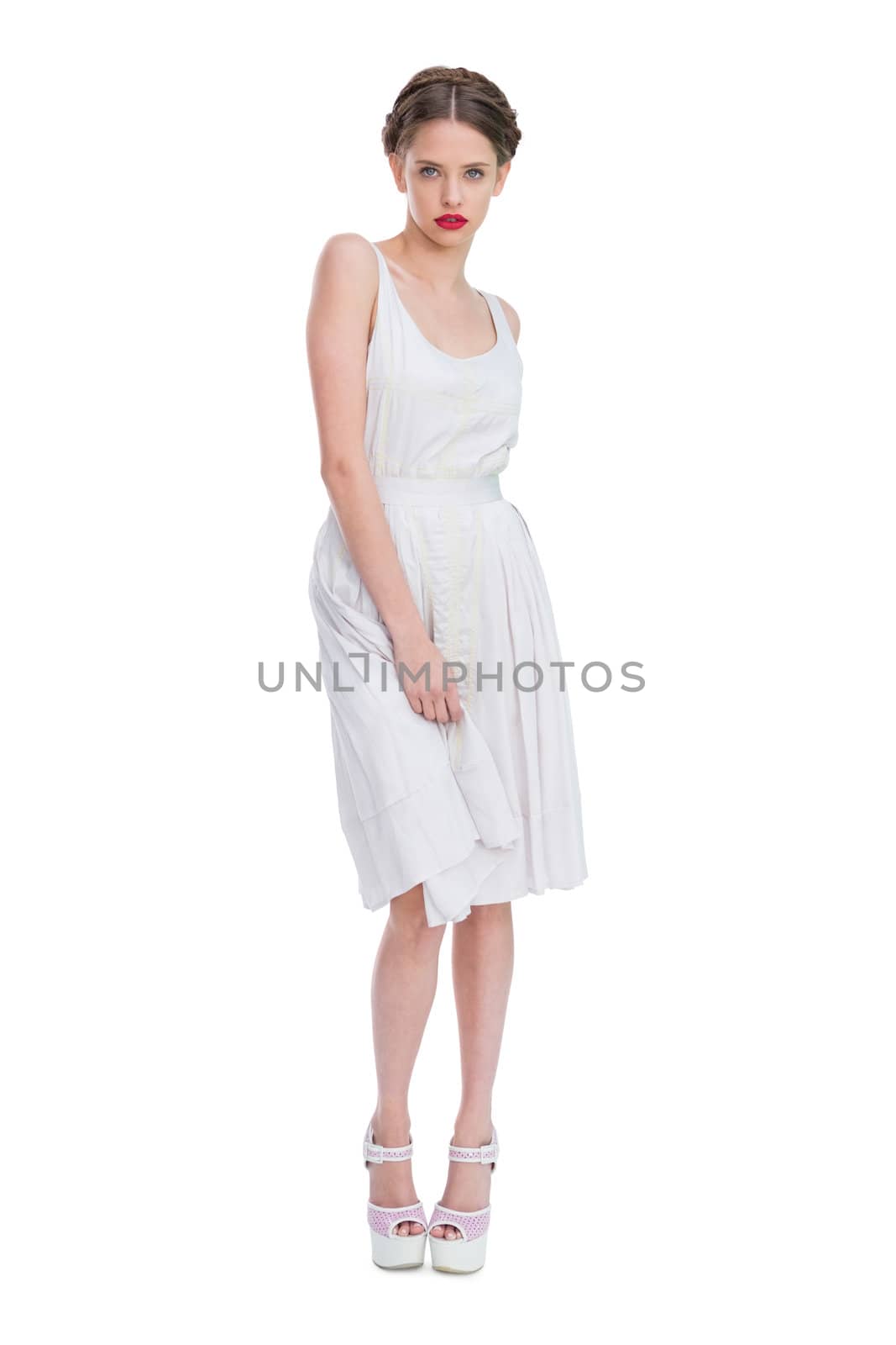 Attractive woman wearing white summer dress standing against white background