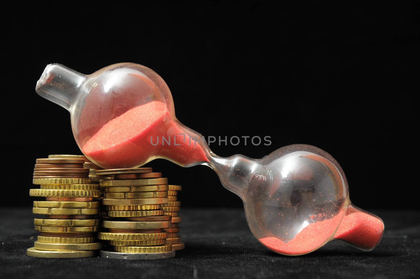 Business Time Concept Money and Hourglass on a Black Background