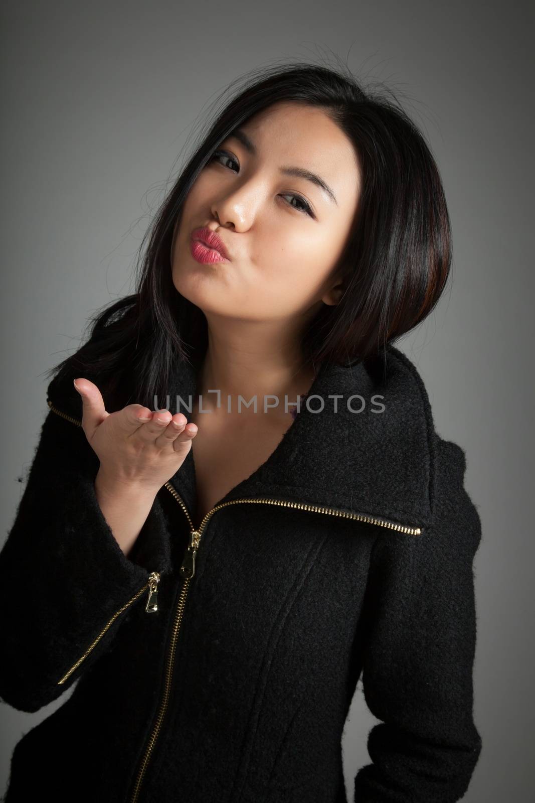 Attractive asian girl in her twenties isolated on a plein background shot in a studio
