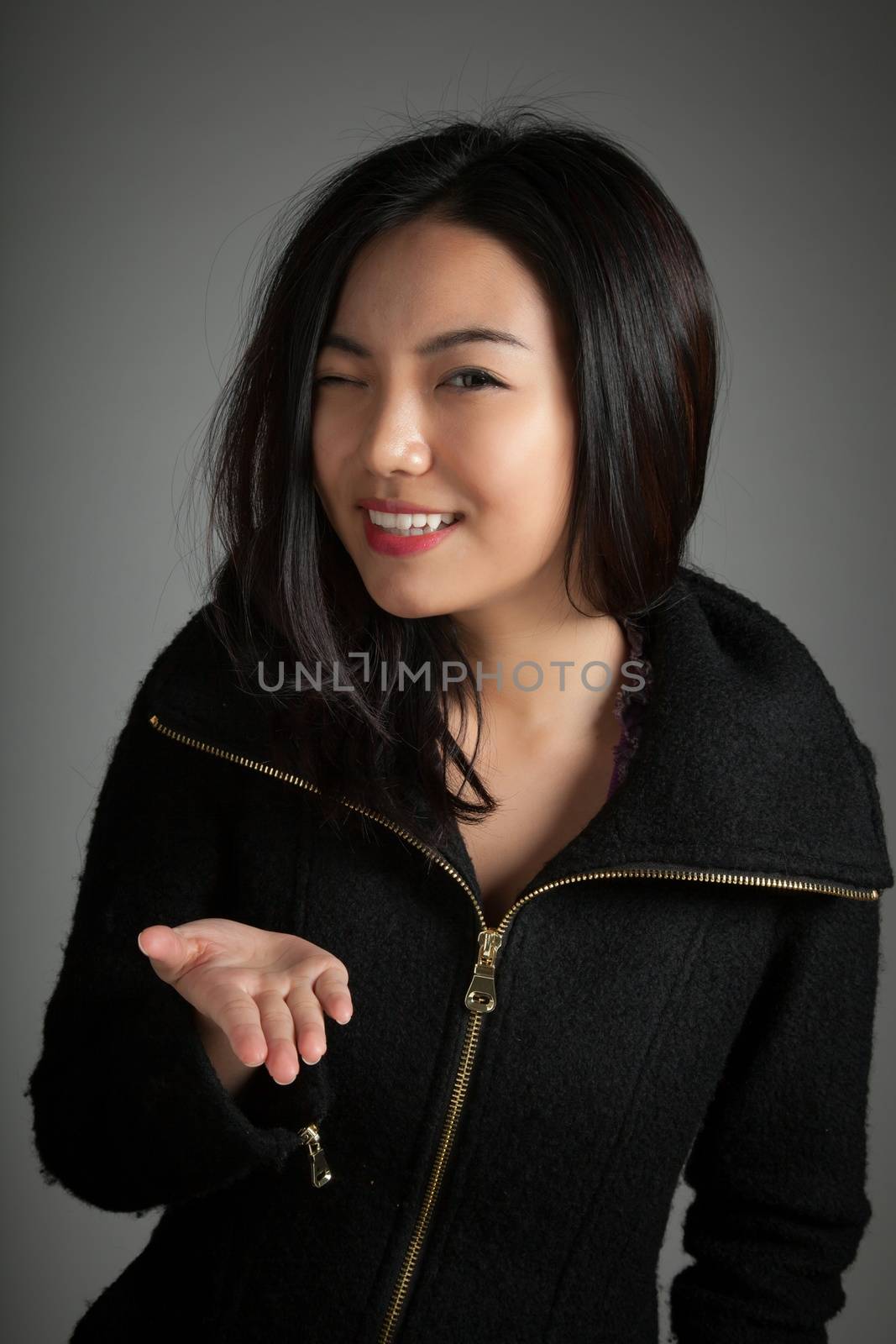 Attractive asian girl in her twenties isolated on a plein background shot in a studio