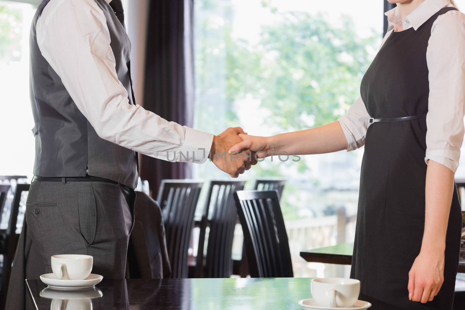 Business people shaking hands after meeting in a cafe