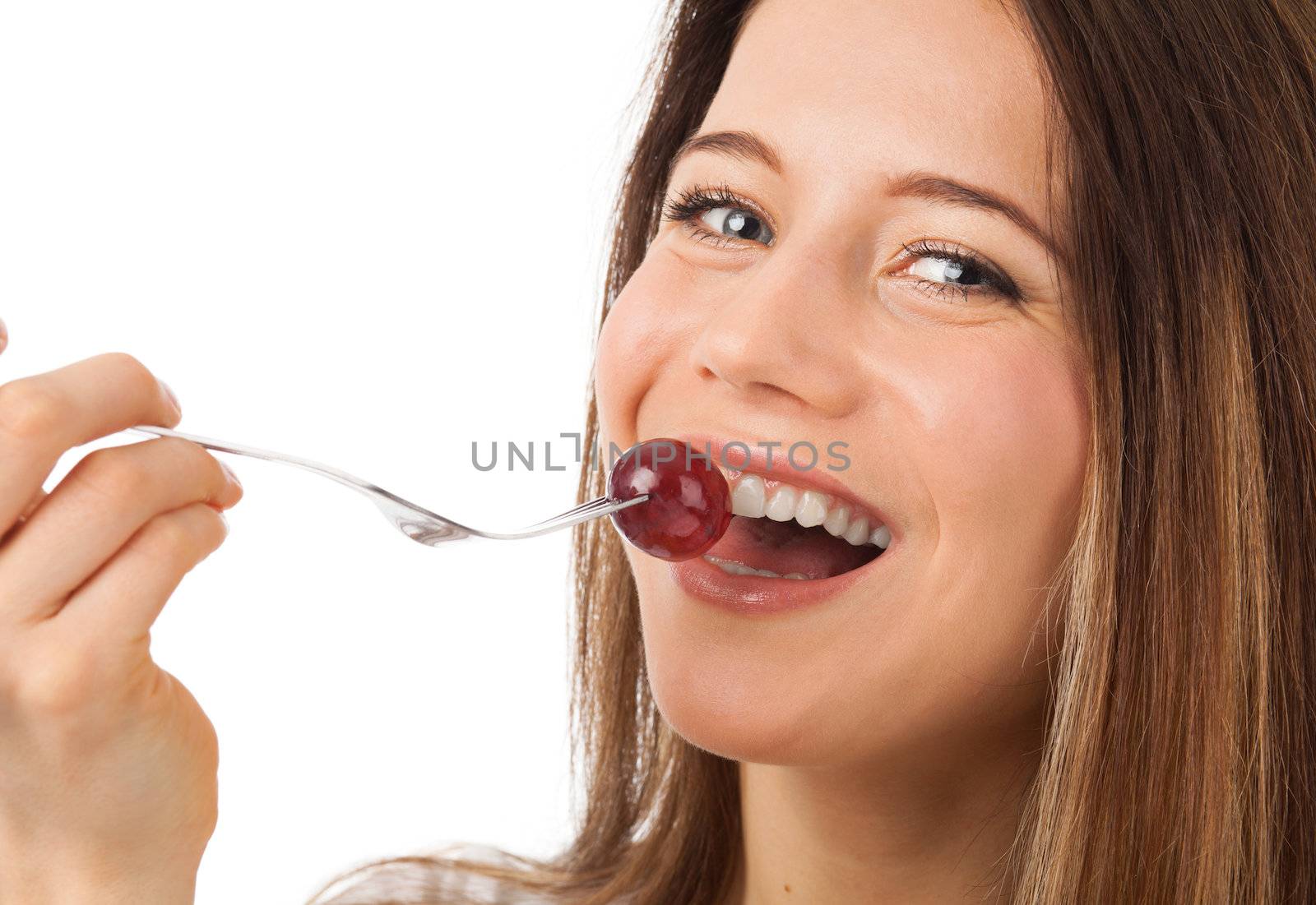 Close up portrait of a nice woman eating grape, isolated on white