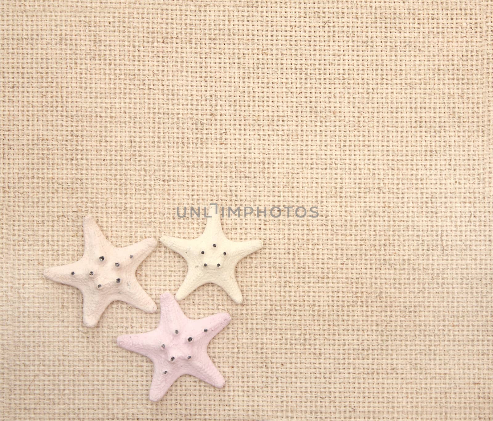 Background with starfishes on canvas texture