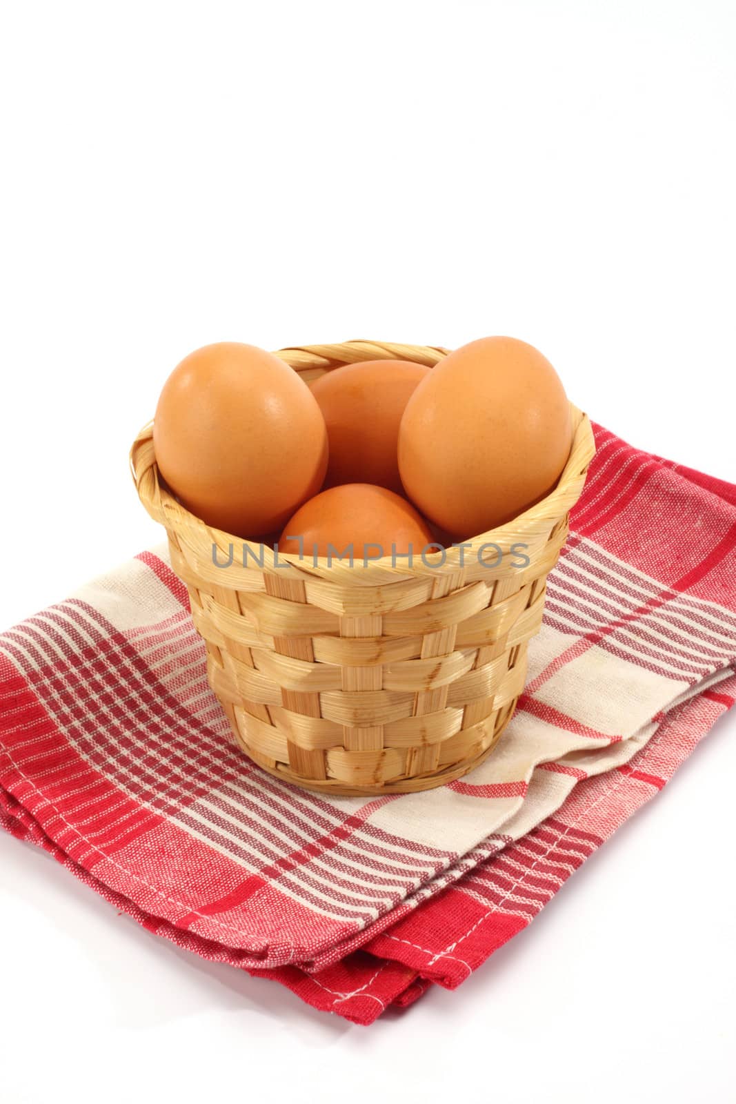 Fresh eggs in basket over white