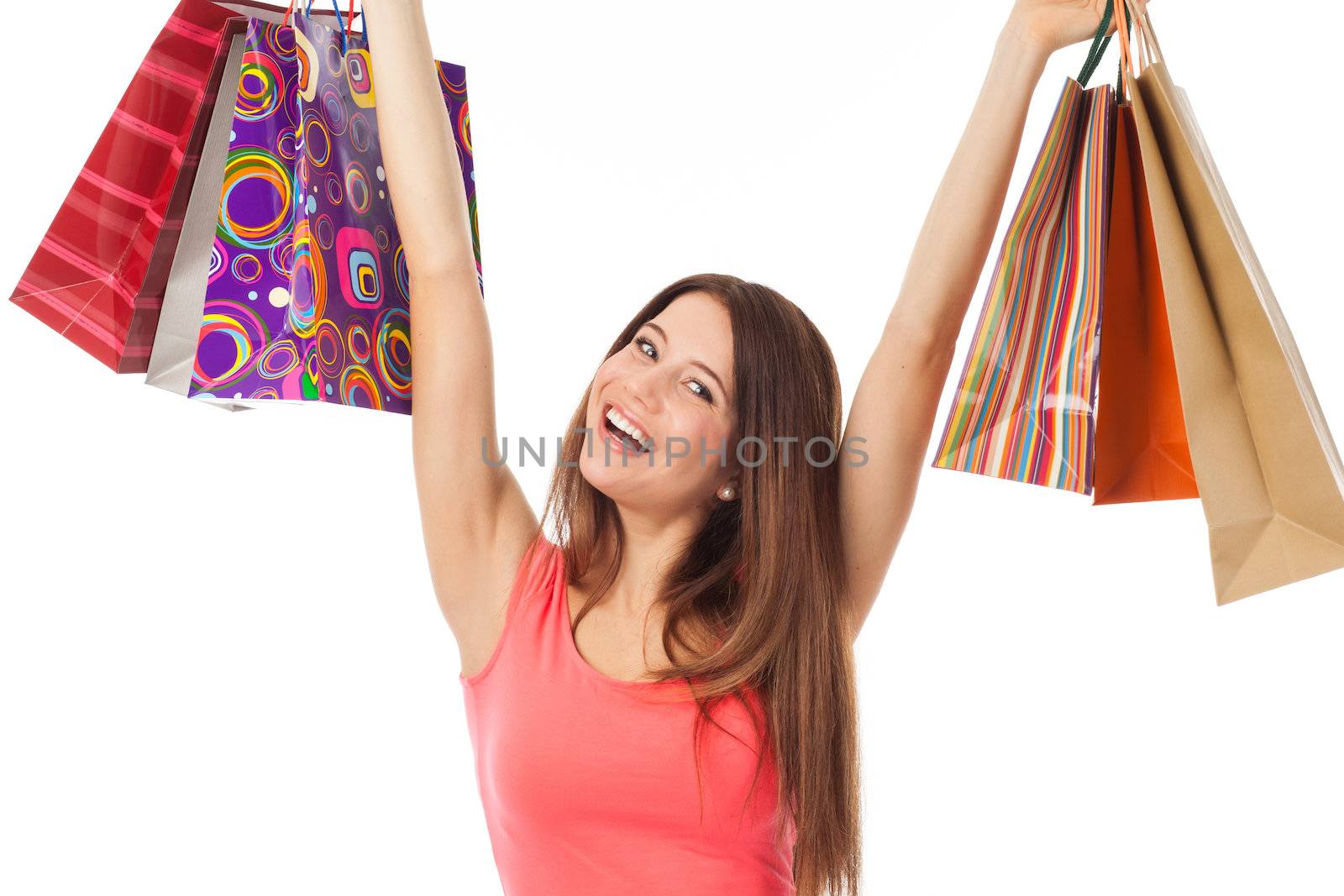 Pretty brunette holding shopping bags and looking very happy, isolated on white