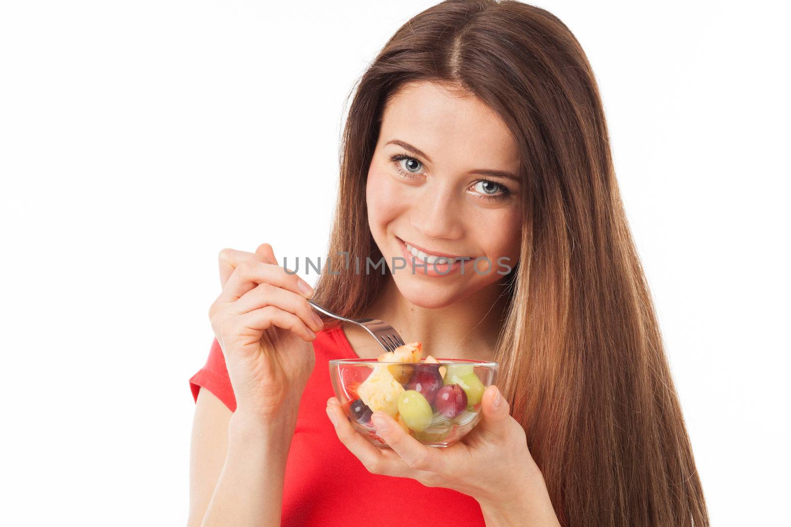 Young woman eating fruits and smiling, isolated on white