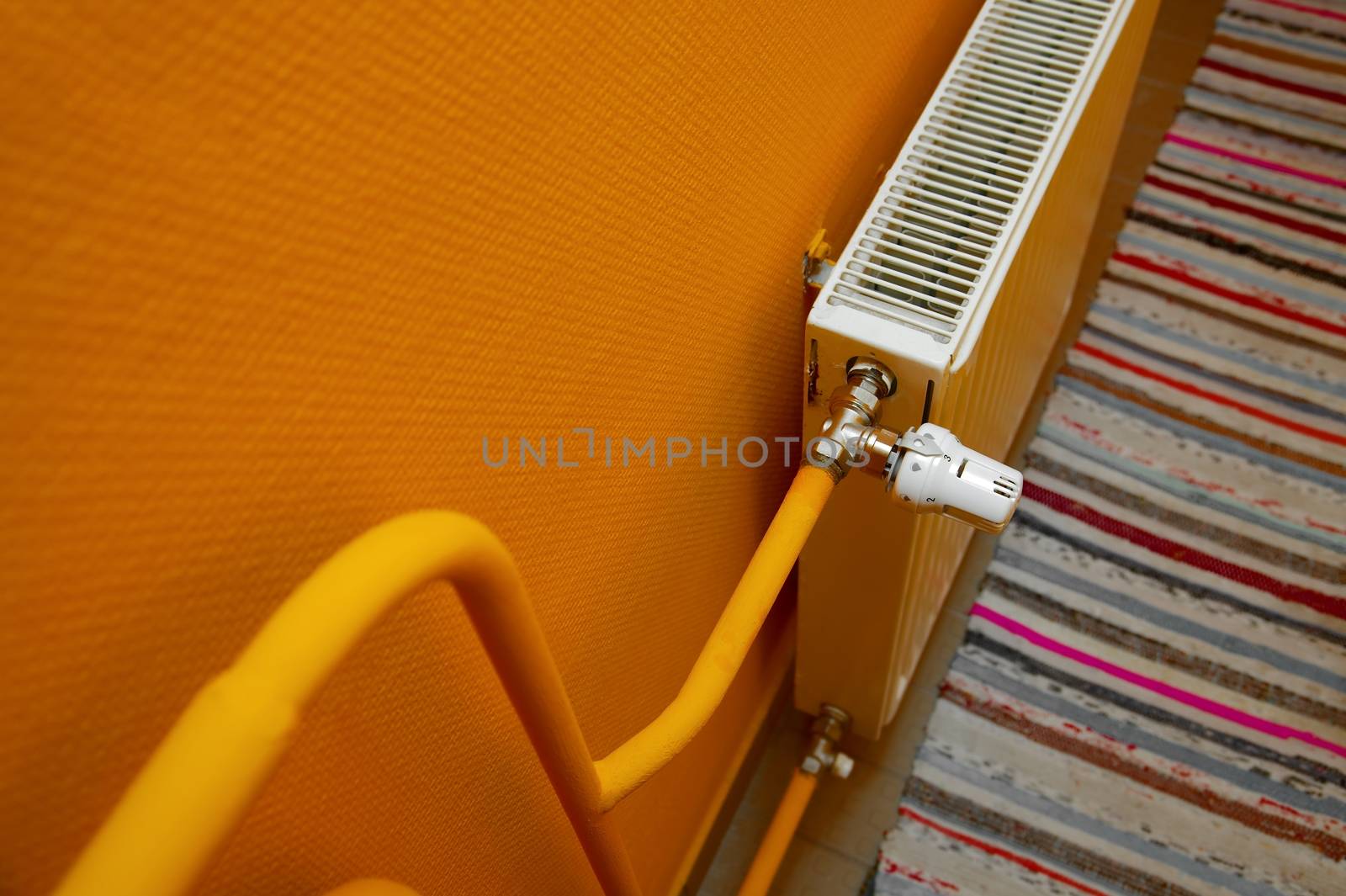 Heating radiator detail against orange wall