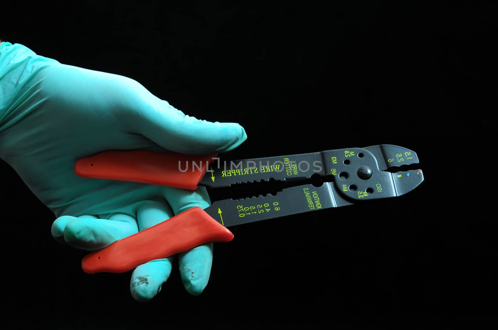 Pliers and a Hand on a Black Background