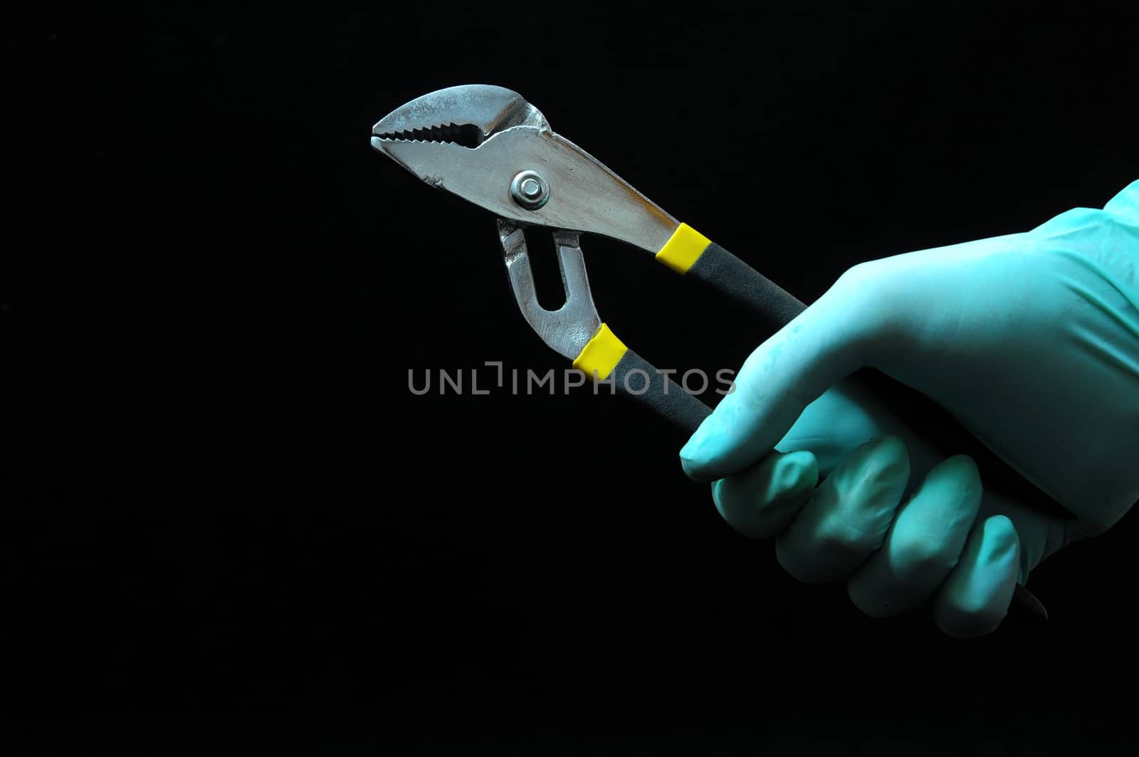 Pliers and a Hand on a Black Background