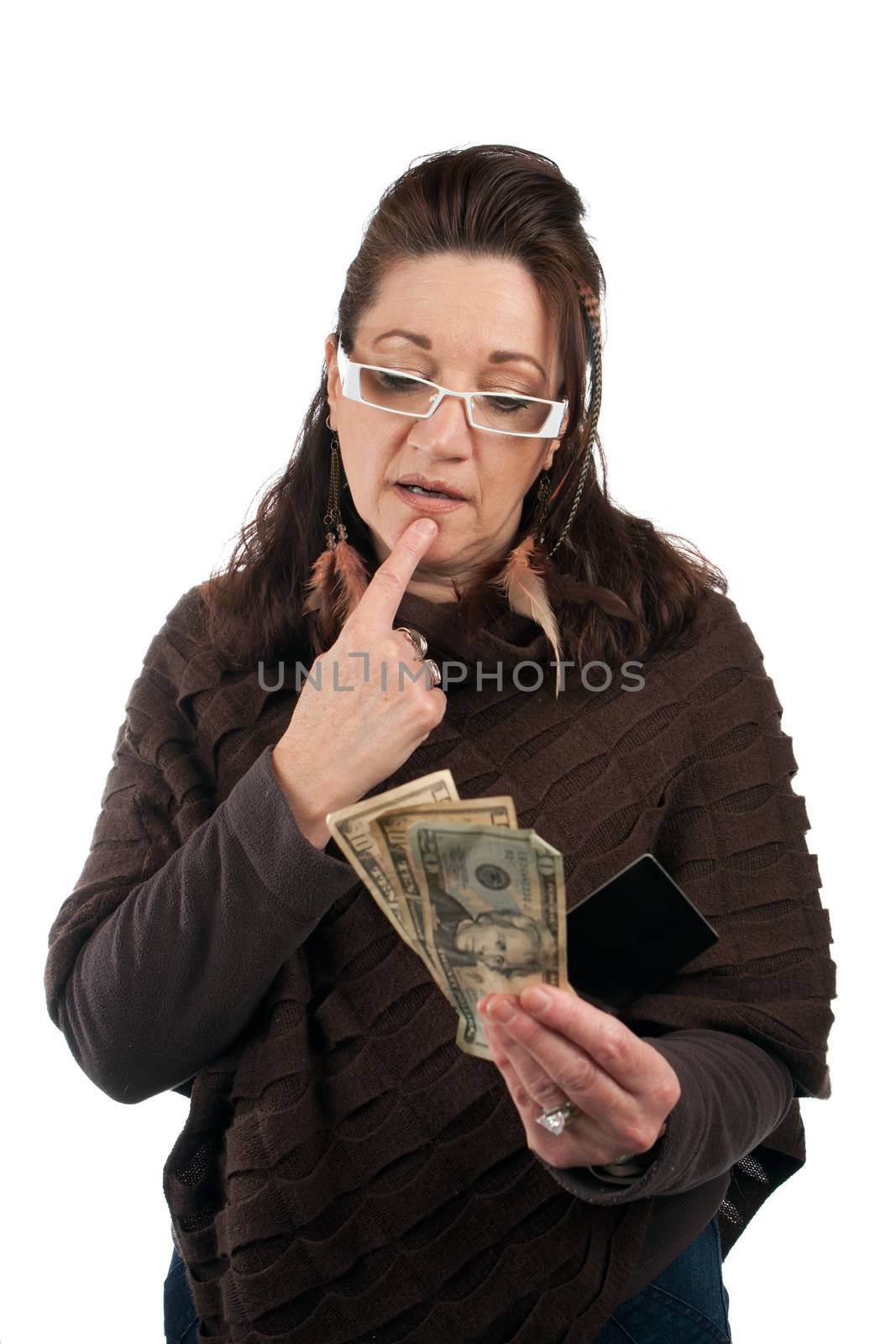 Middle aged woman carefully trying to decide between using old fashioned cash or a plastic credit or gift card.