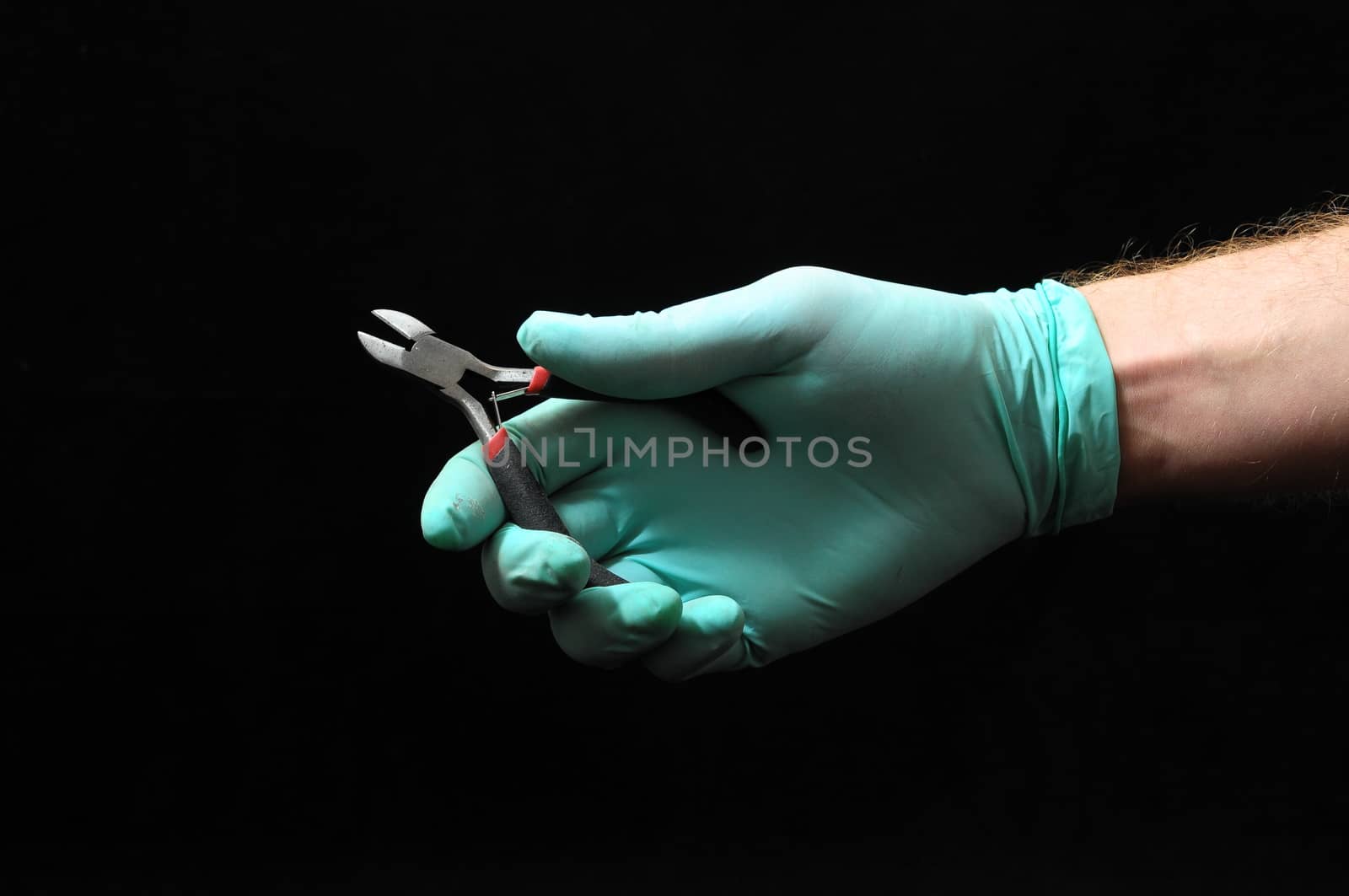 Cutter Pliers and a Hand on a Black Background