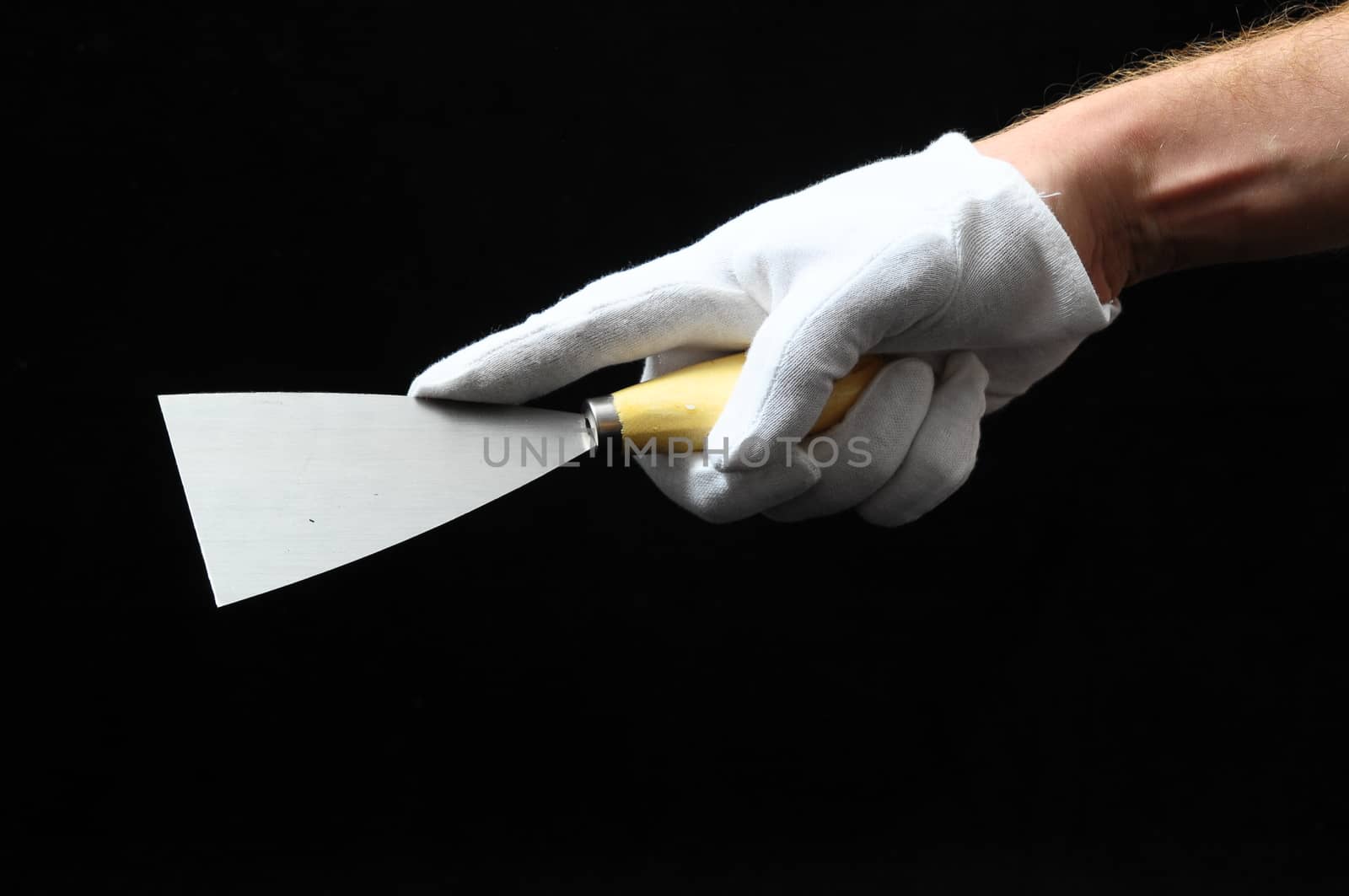 One Spatula and a Hand on a Black Background