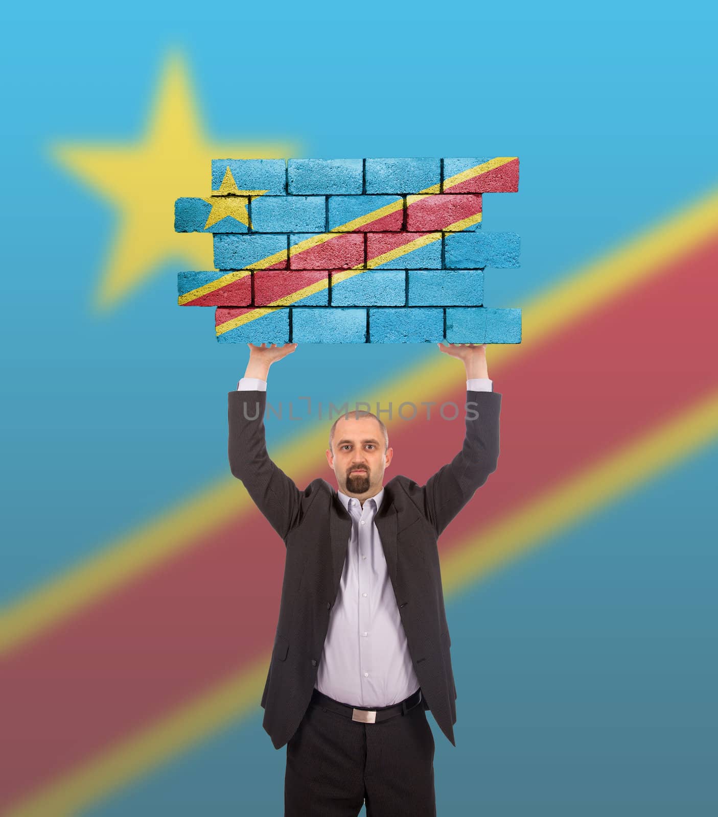 Businessman holding a large piece of a brick wall, flag of Congo, isolated on national flag