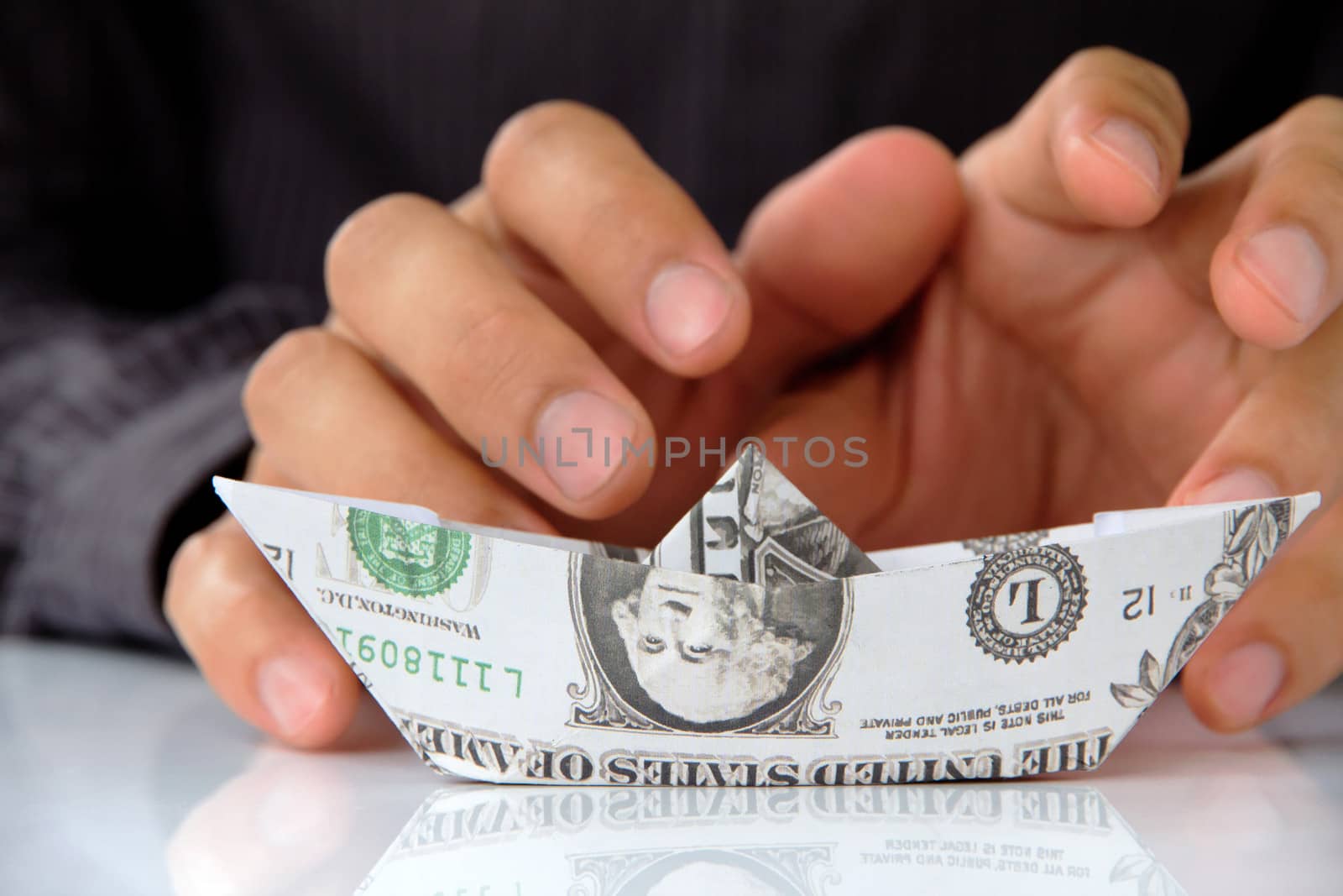 business man hand holding origami paper sailboat, money concept by ponsulak