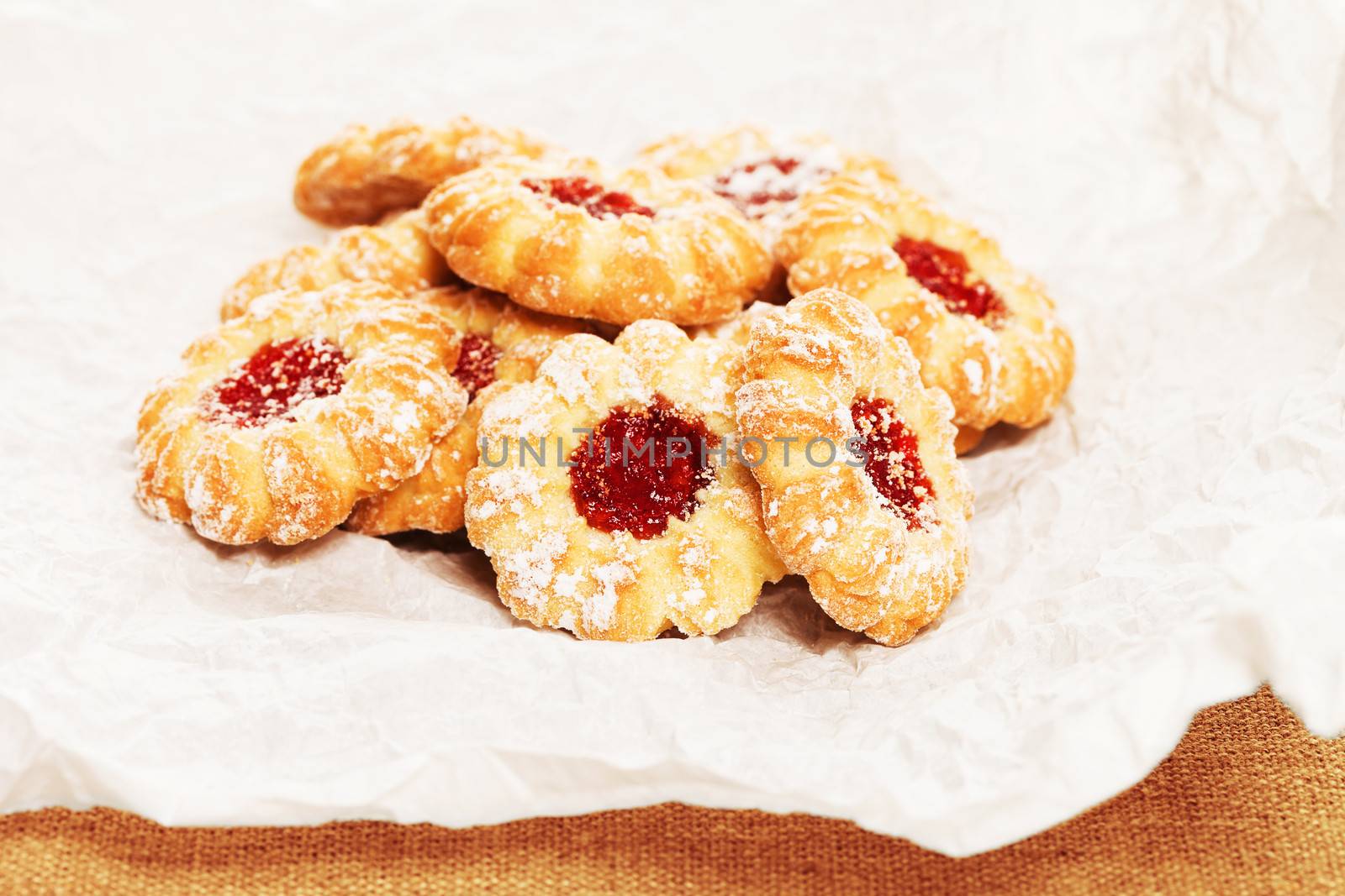 pile of some christmas cookies with jam on a parchment paper