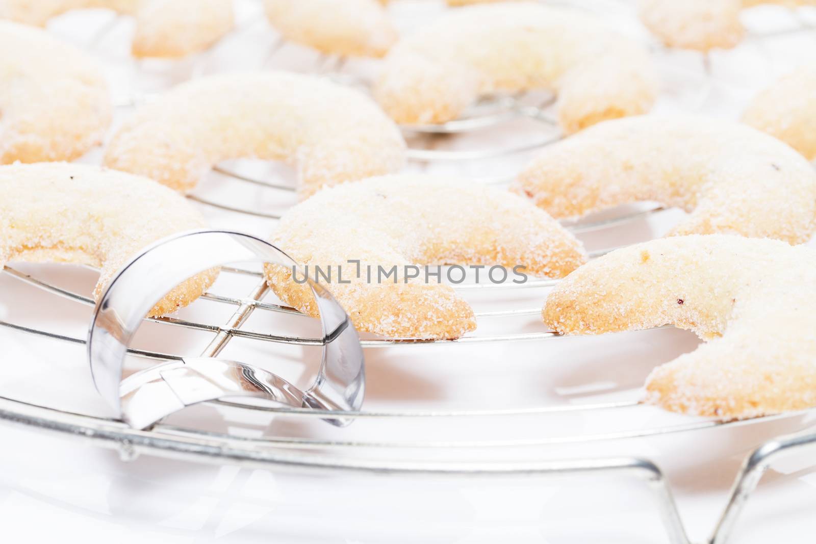 fresh baked christmas vanilla crescents on a cooling grid with a mold