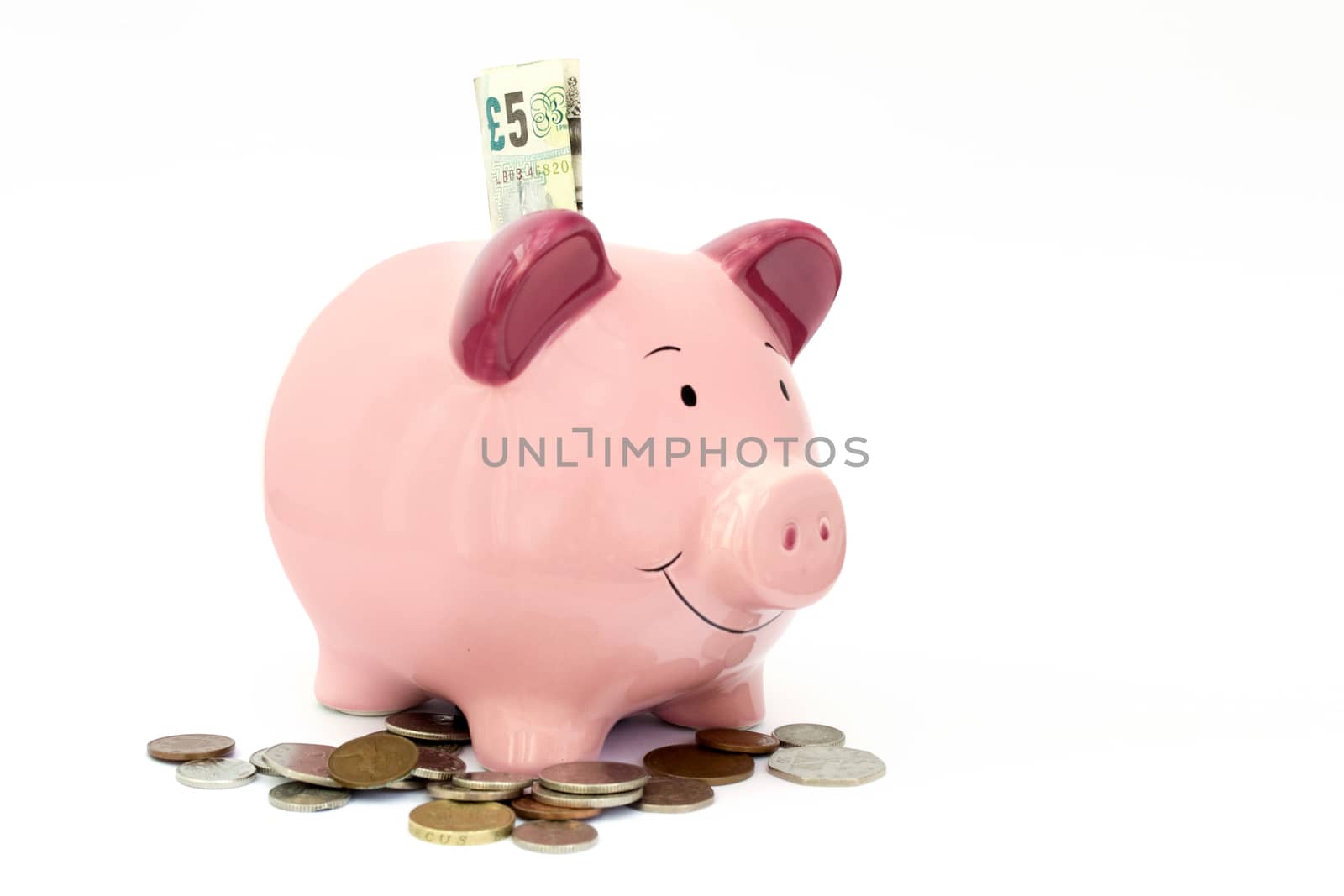 Piggy bank with money around it on a white background