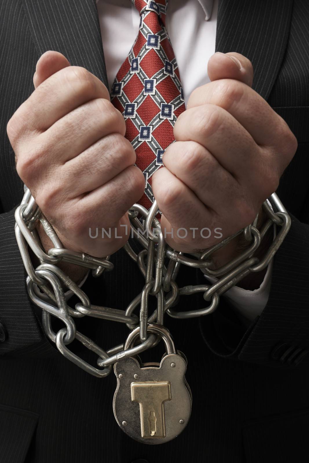 Close up of businessmans hands tied in heavy chains with padlock