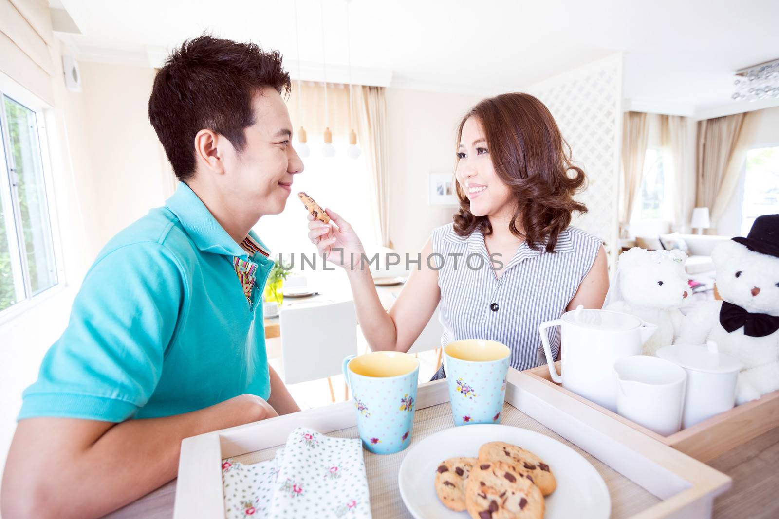 Young happy couples in domestic kitchen with breakfast