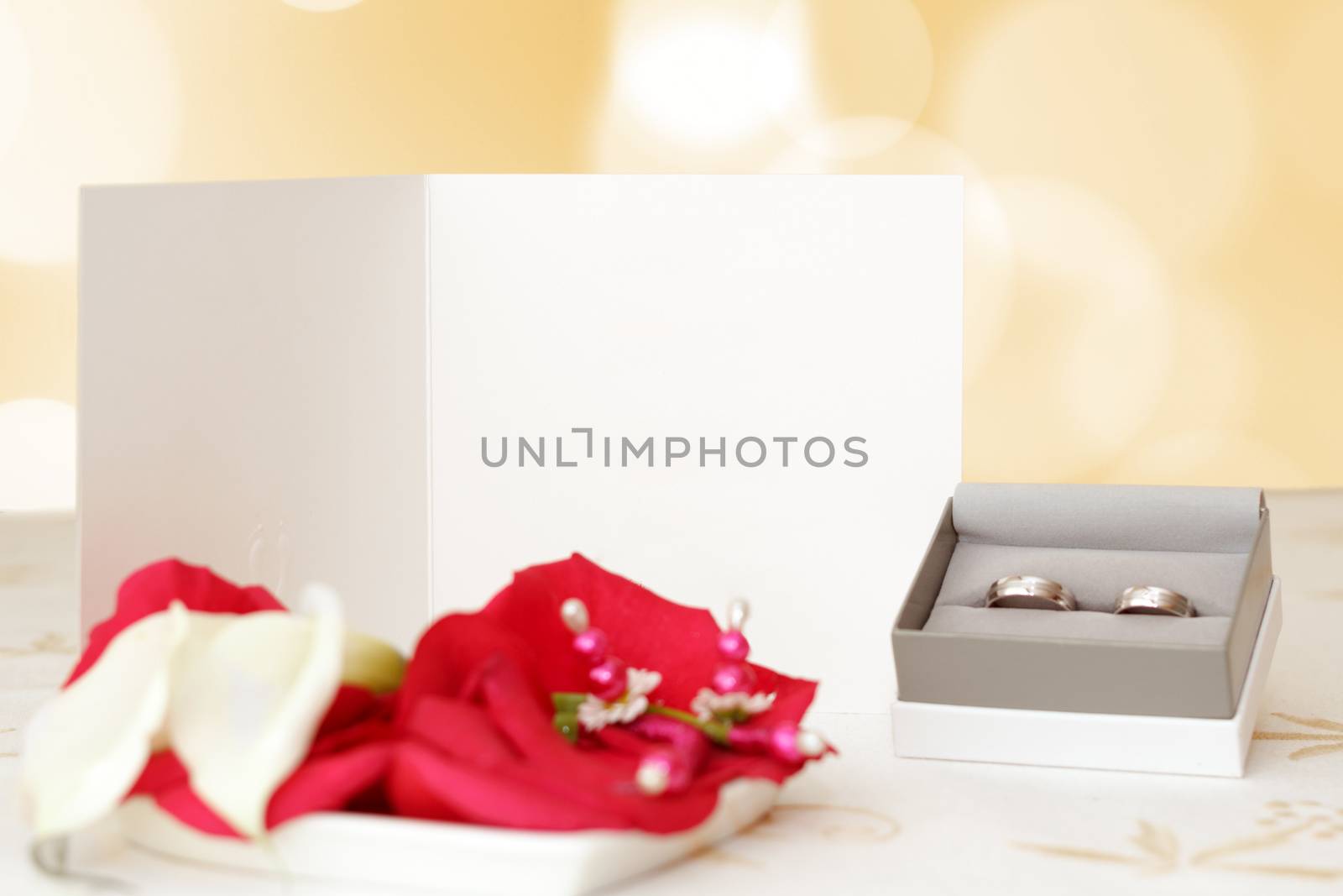 wedding announcement with rings and space for text, focus wedding announcement, blurred rings, focus to white paper with space for text