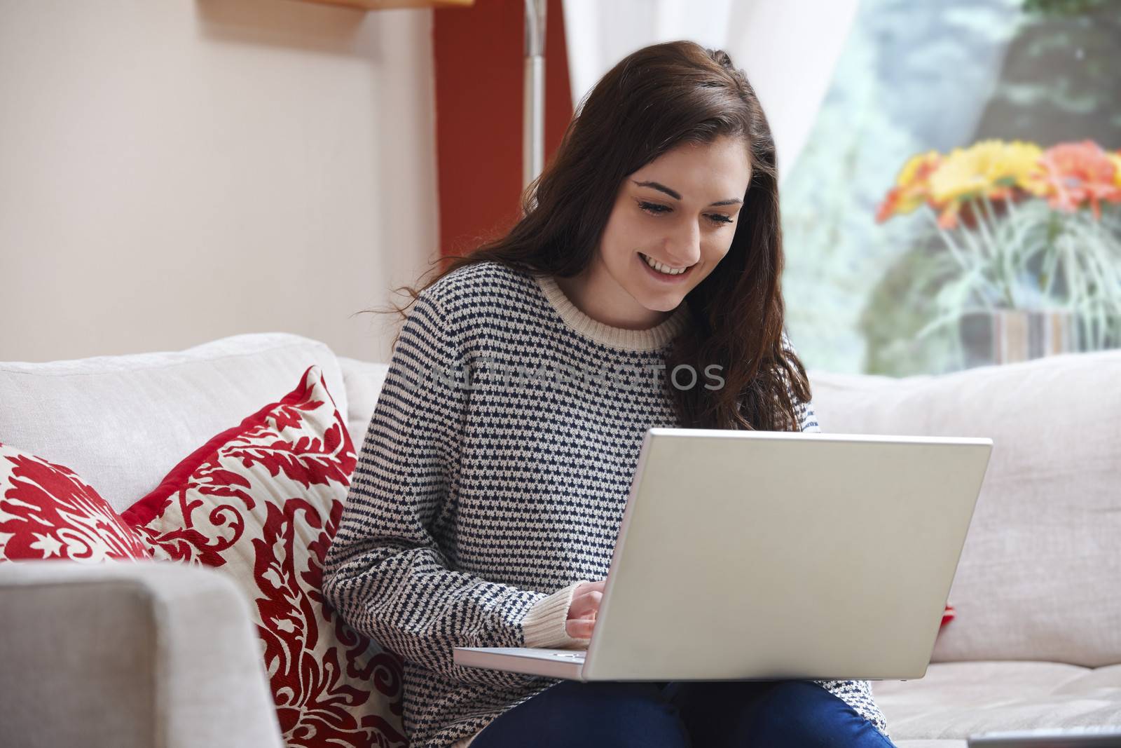 Teenage girl using a laptop computer while sitting at home