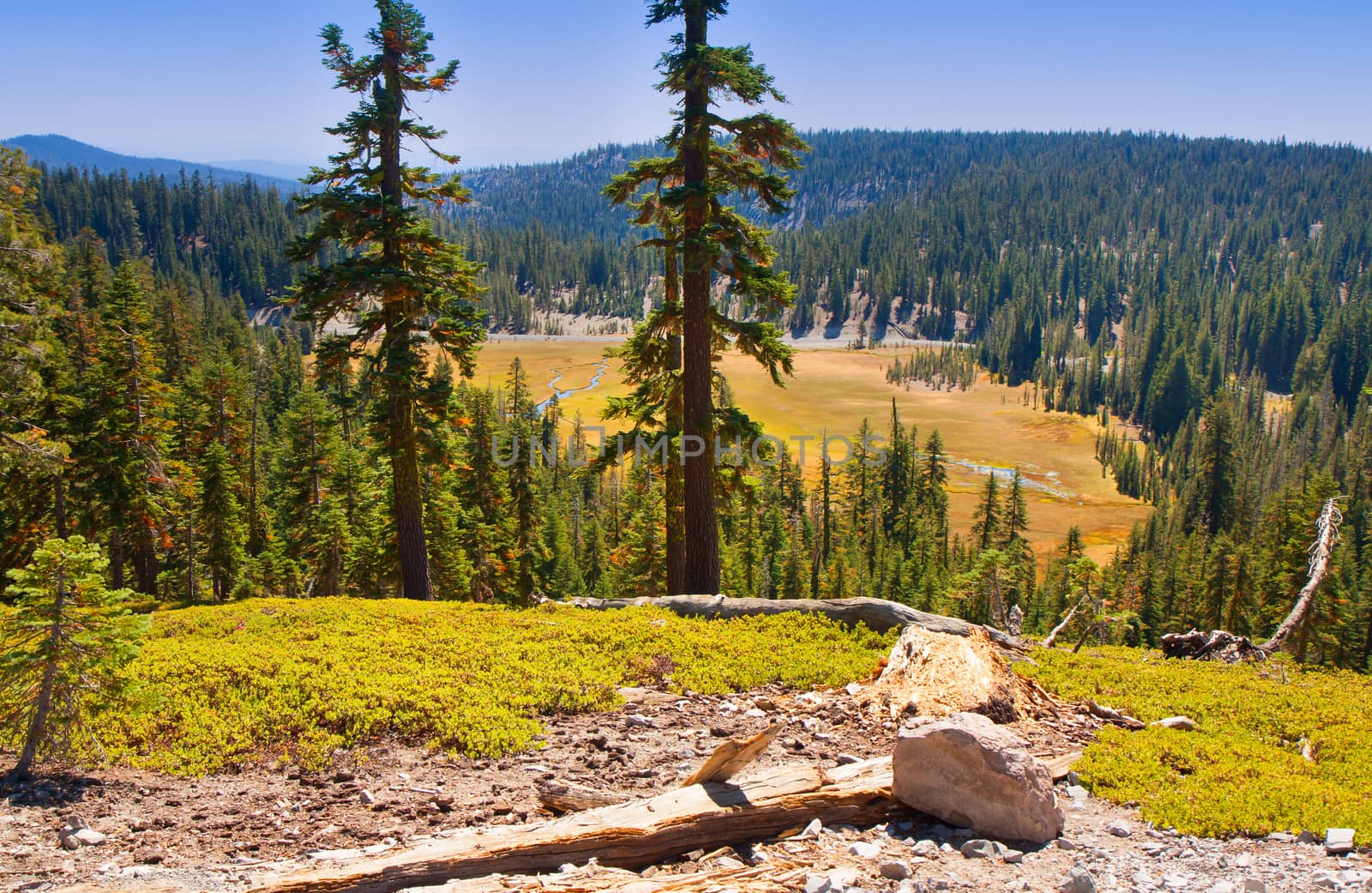 This image of Mount Lassen National Park shows beautiful hills and a valley adorned with greenery.