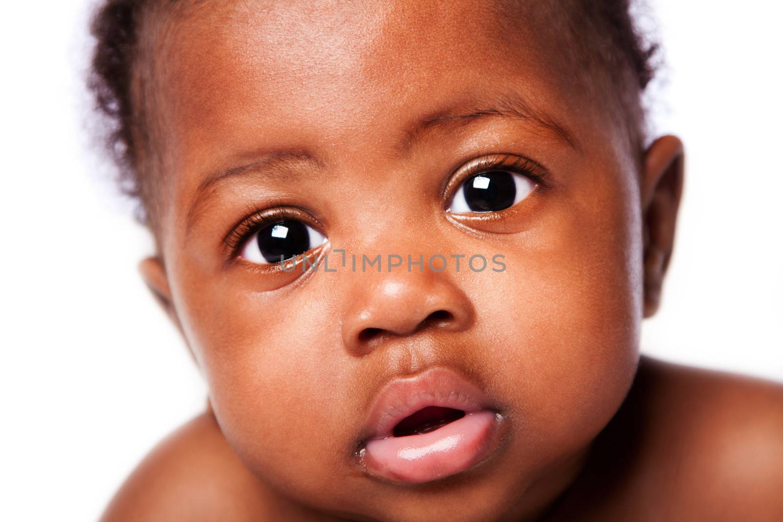 Closeup of cute adorable beautiful face of African baby with innocent expression, on white.