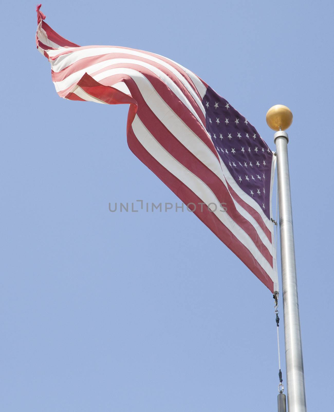 American flag waving with blue sky in the background