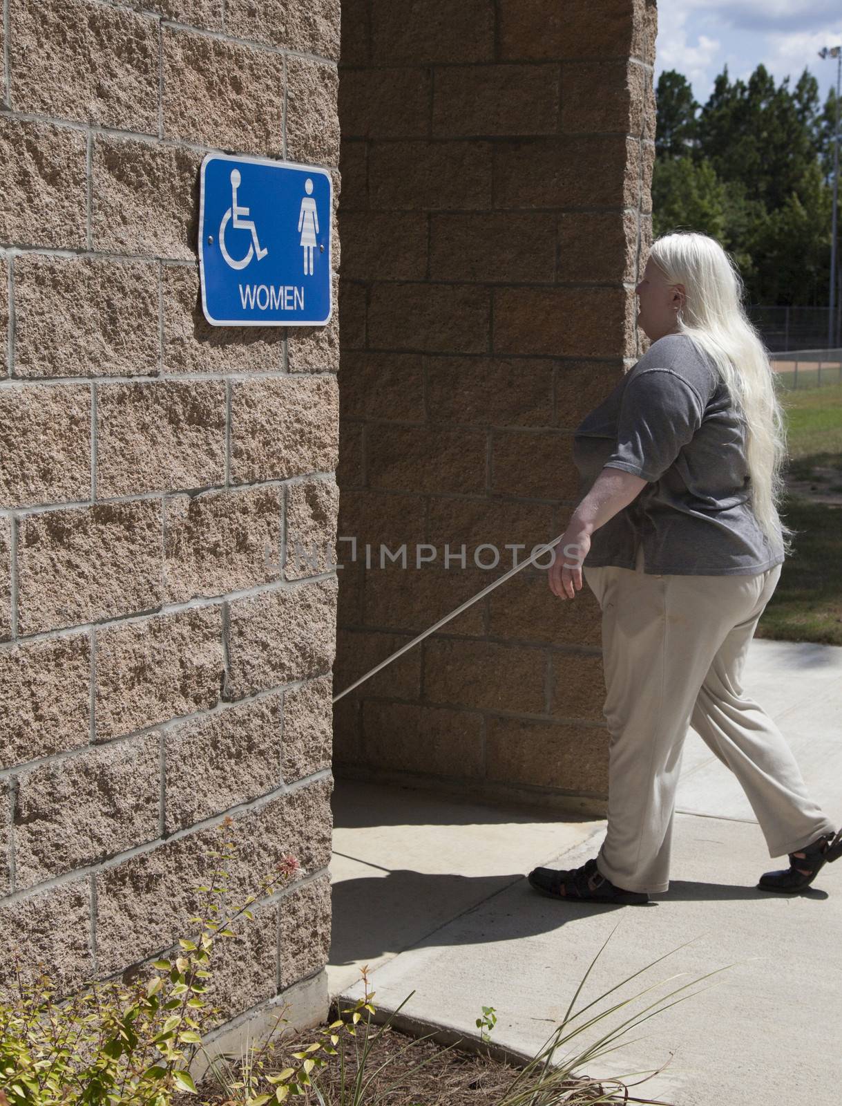 Blind waman walking into the women's restroom