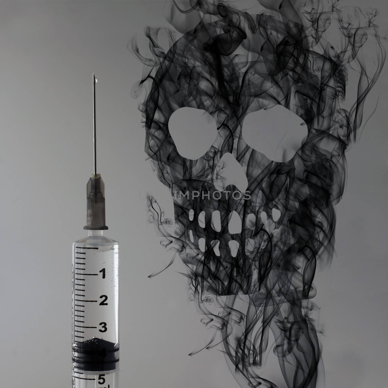 Syringe over gray background and skull of black smoke