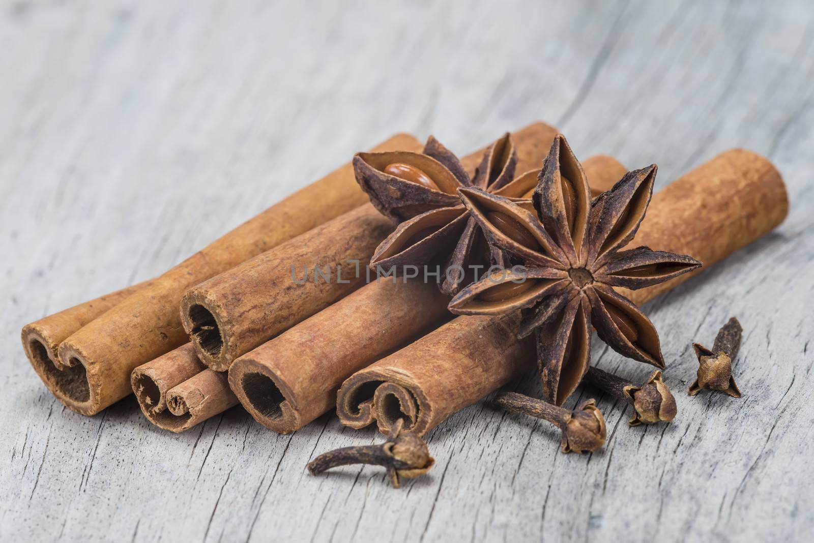 Cinnamon with anise and clove over wood by angelsimon