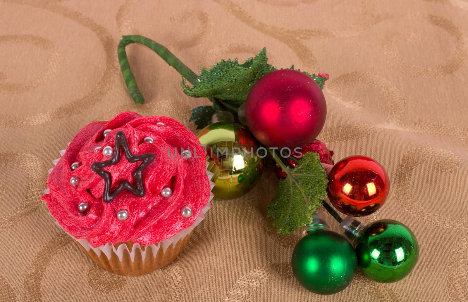 Christmas cupcake with tree ornament on gold background