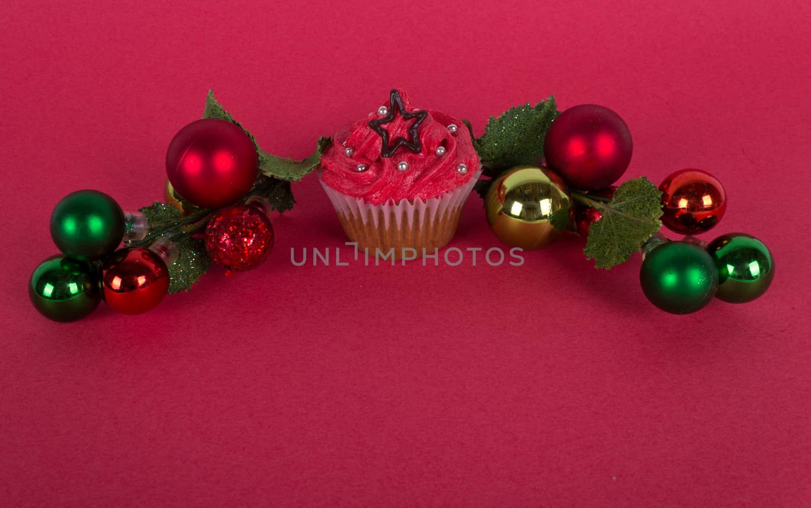 Christmas cupcake and tree ornaments on red background