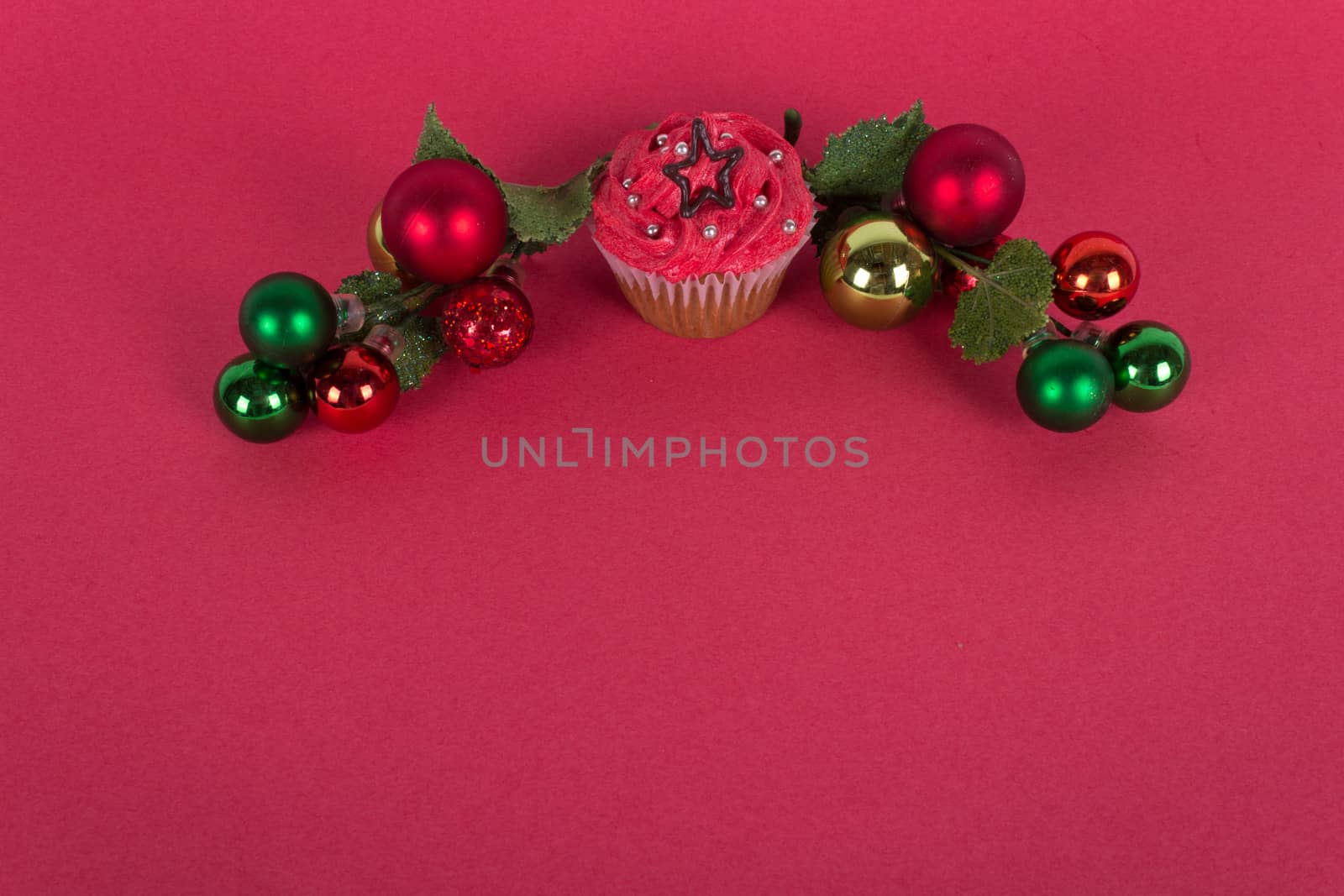 Christmas cupcake and tree ornaments on red background