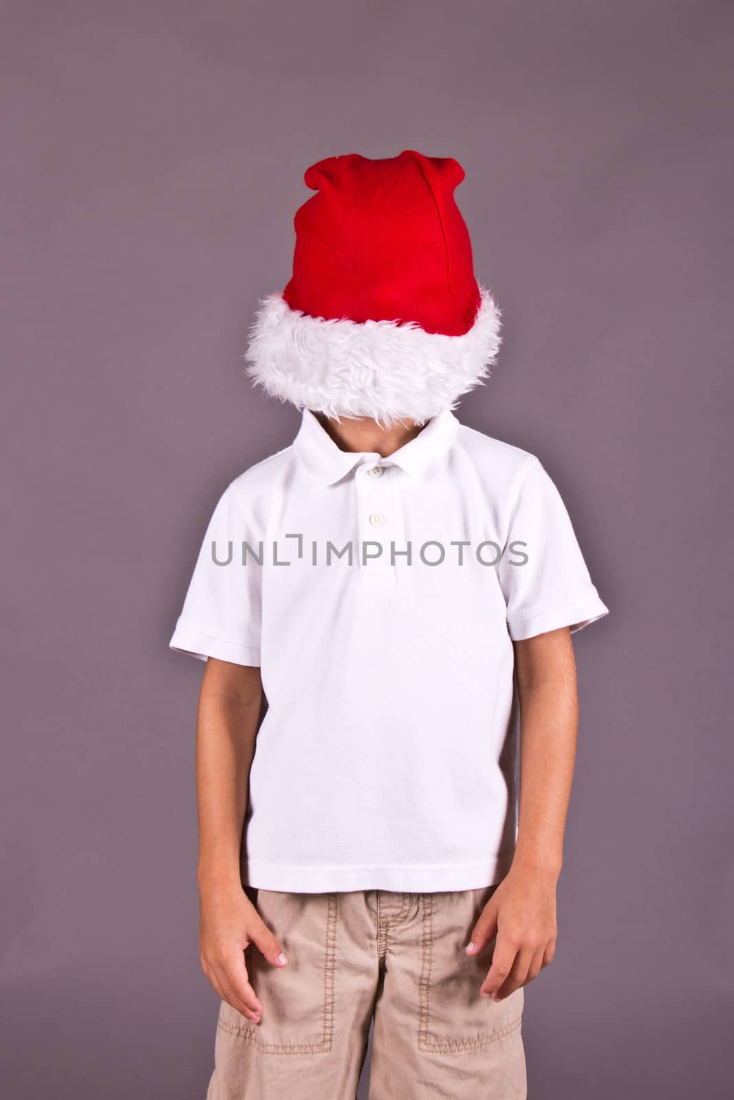 Boy being silly with Santa hat during Christmas