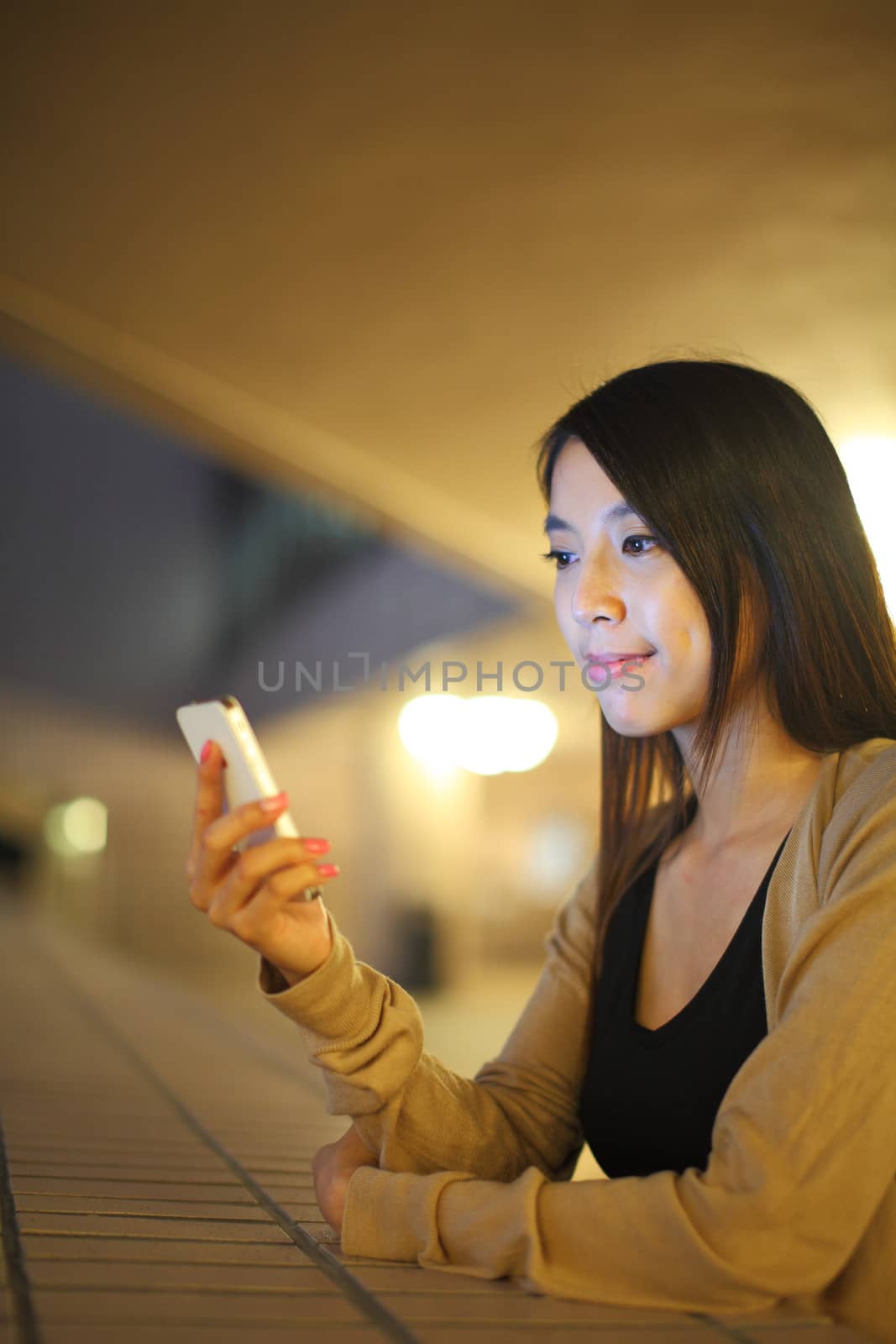 woman using phone in city at night