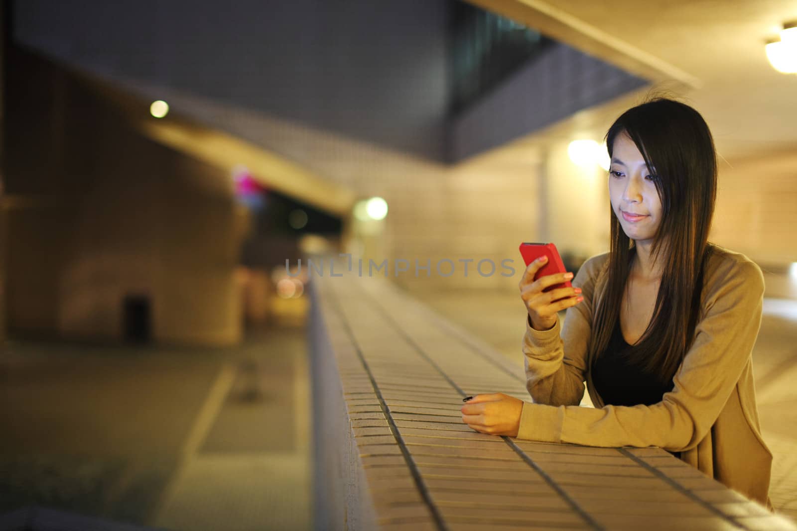 woman using mobile phone in city at night