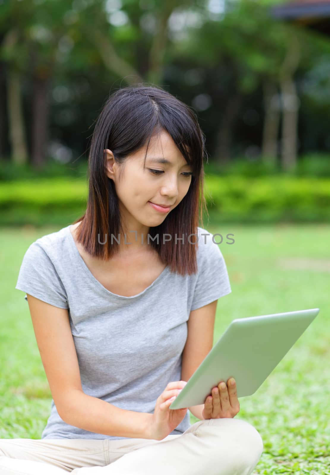 Asian woman looking at computer tablet by leungchopan