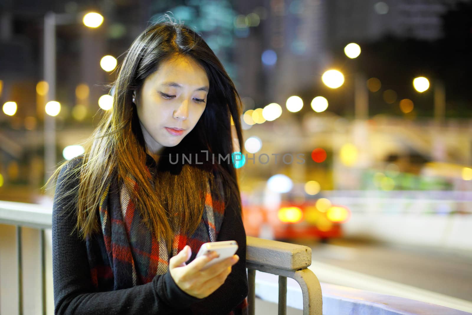 woman using mobile at night by leungchopan
