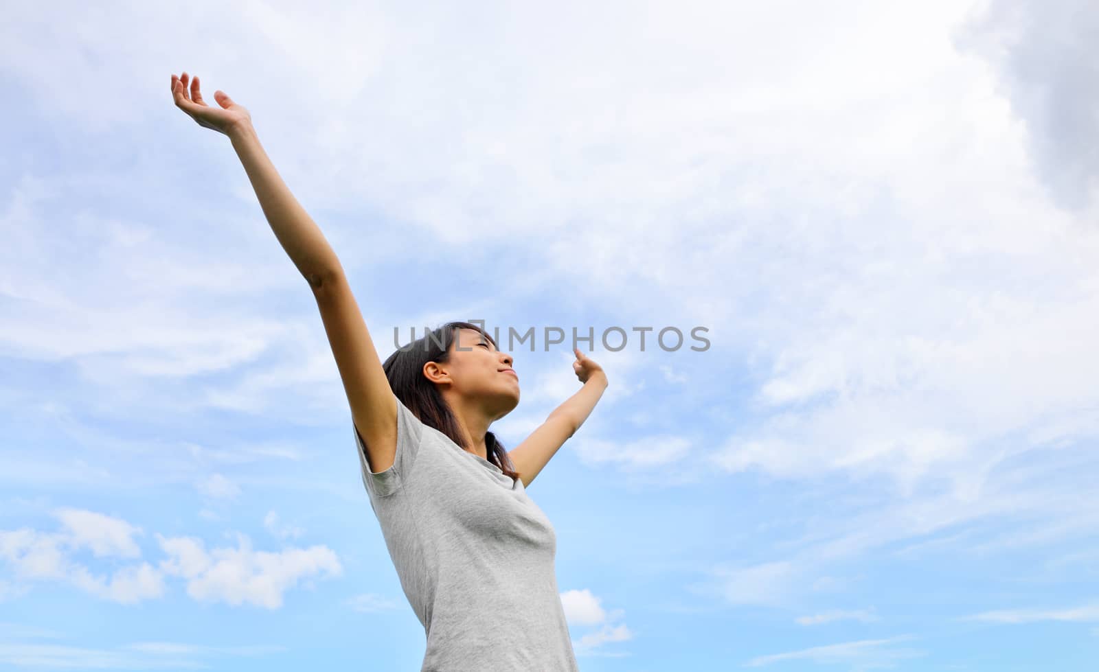 Asian woman hand up with blue sky background by leungchopan