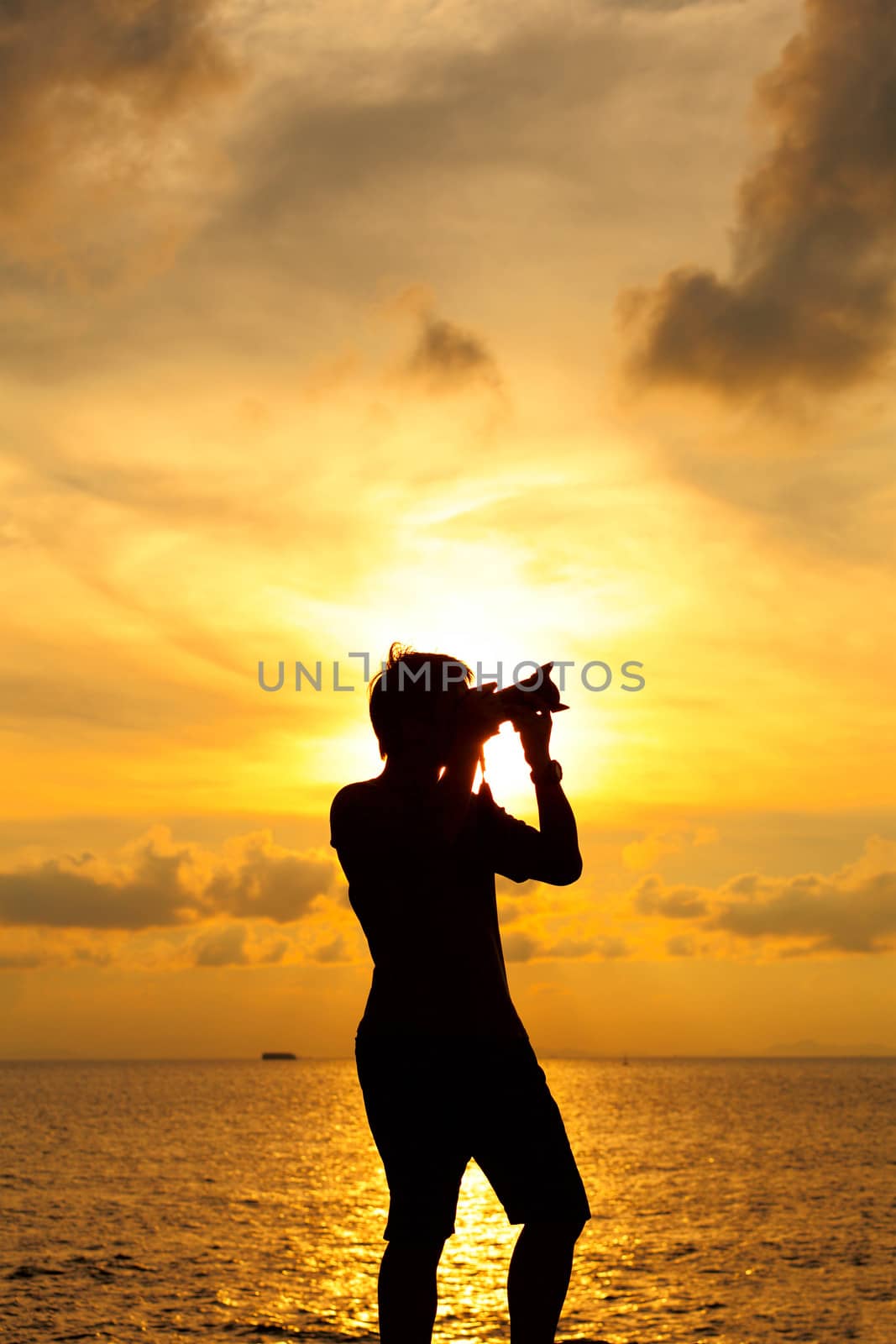 Silhouette photographer at sunset by leungchopan
