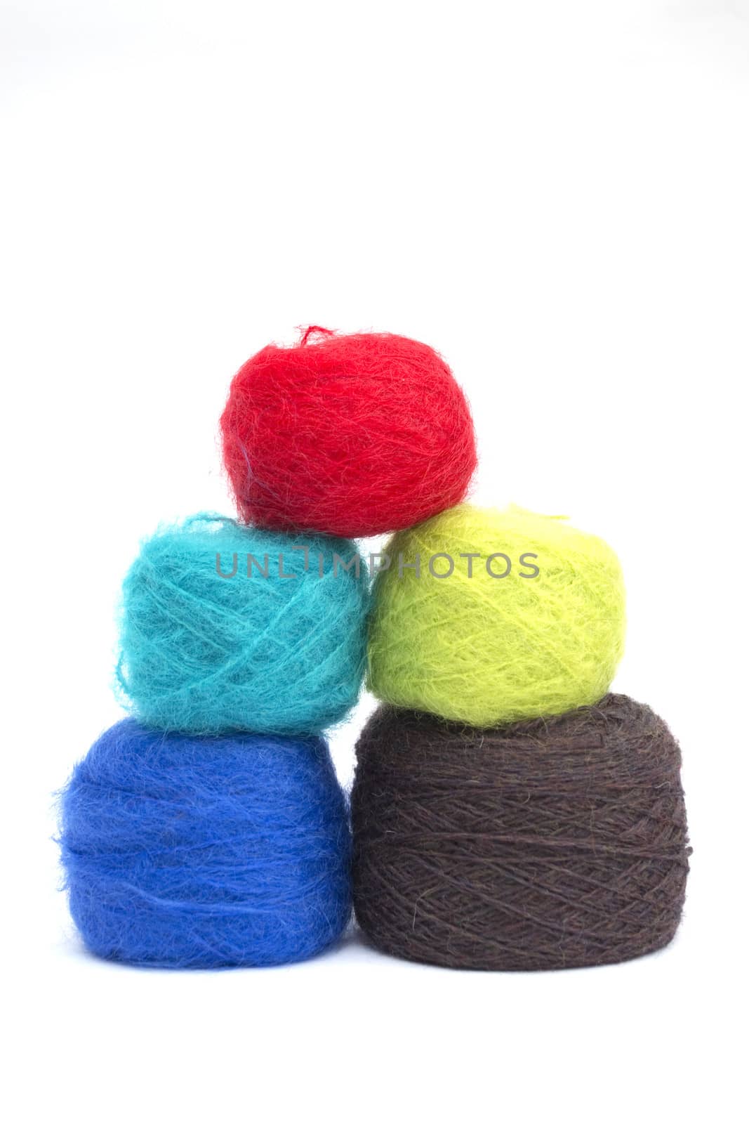 Various balls of coloured wools on a white background