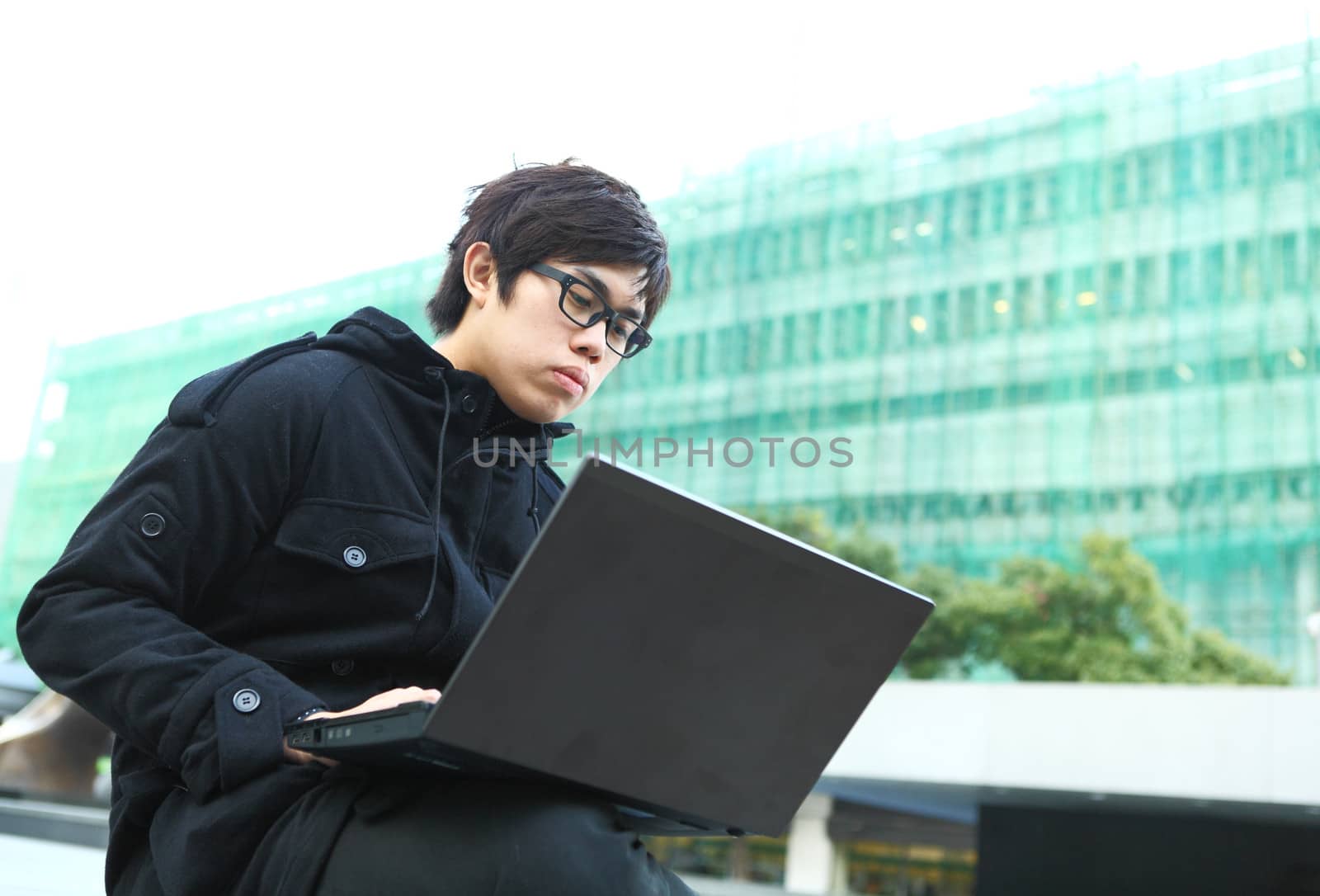 man using computer outdoor by leungchopan