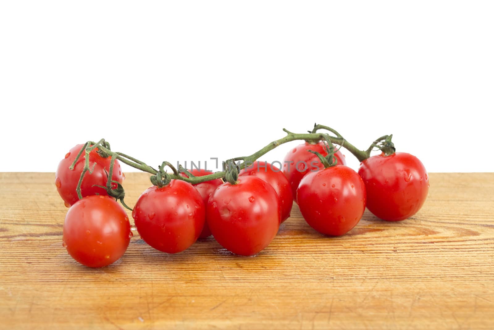 Vine of tomatoes on a wooden board