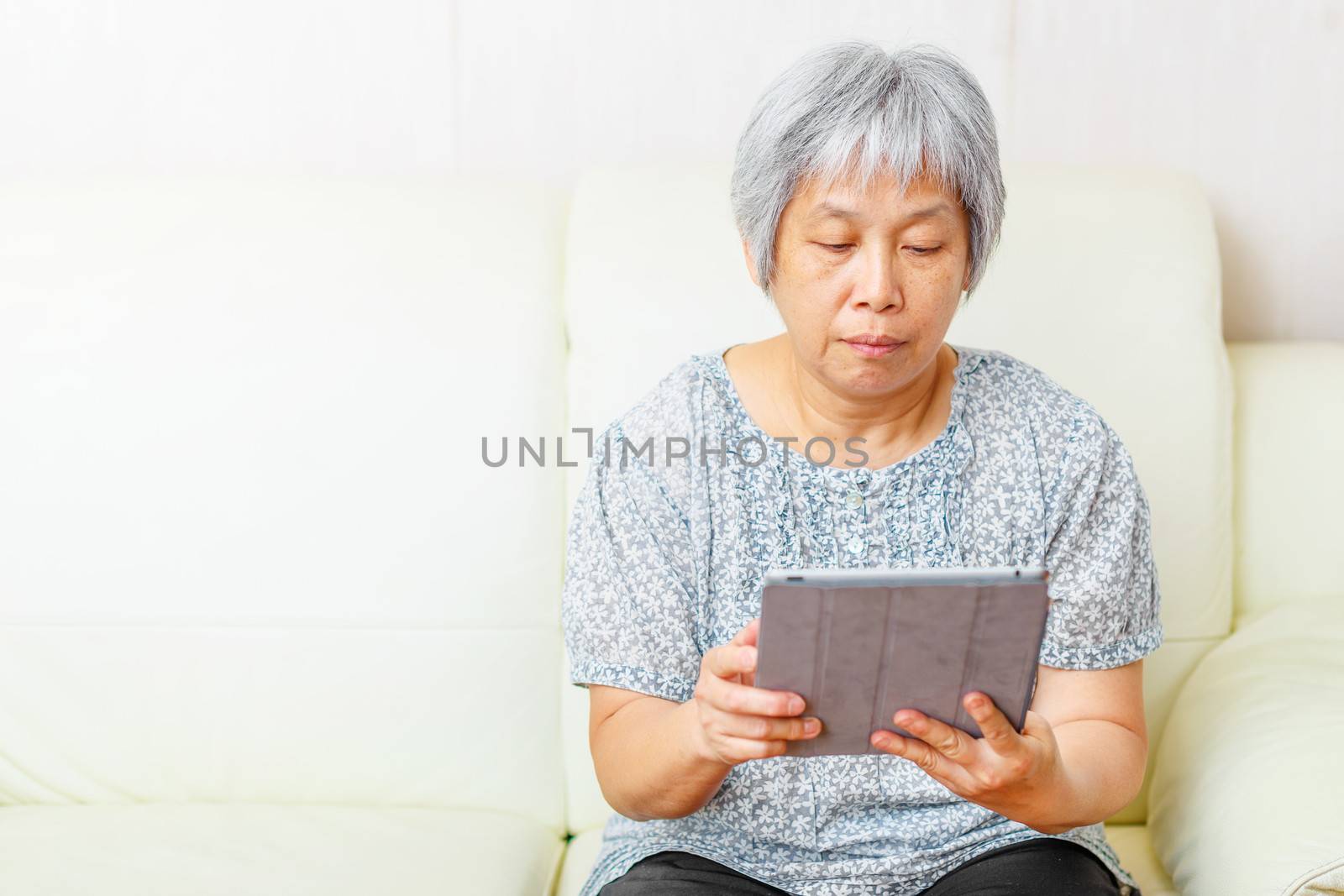 Asian old woman using digital tablet by leungchopan