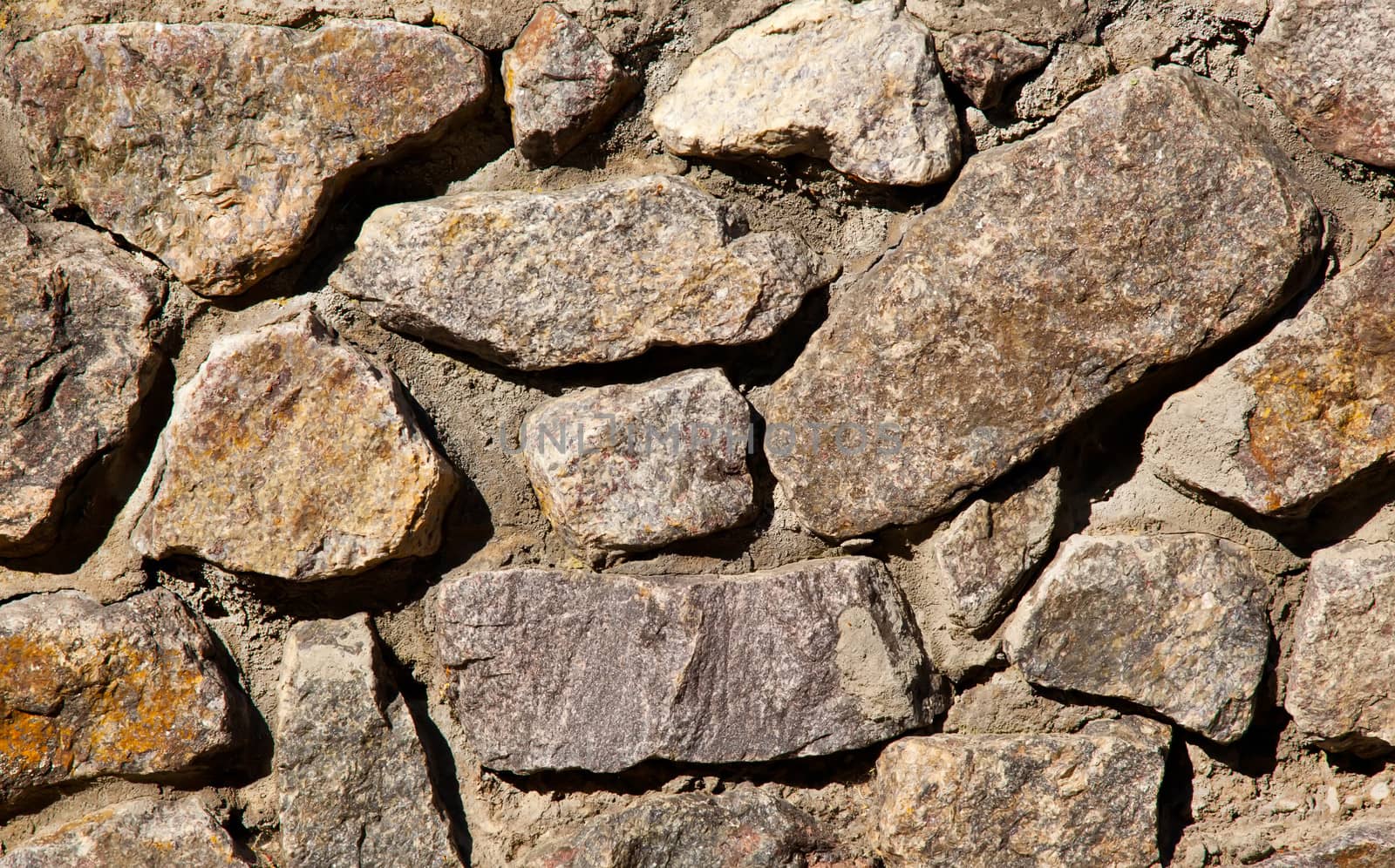 Brown and yellow irregular stone wall background by RawGroup