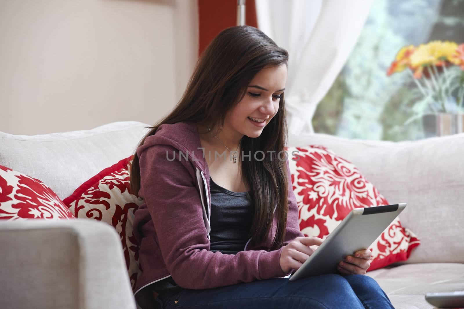 Teenage girl using a tablet pc while sitting at home