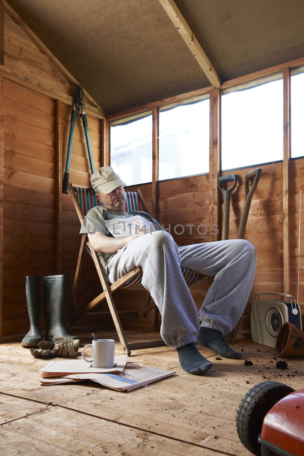 Man sitting in deckchair falling asleep in the shed