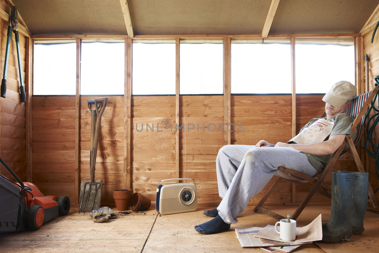 Man sitting in deckchair falling asleep in the shed