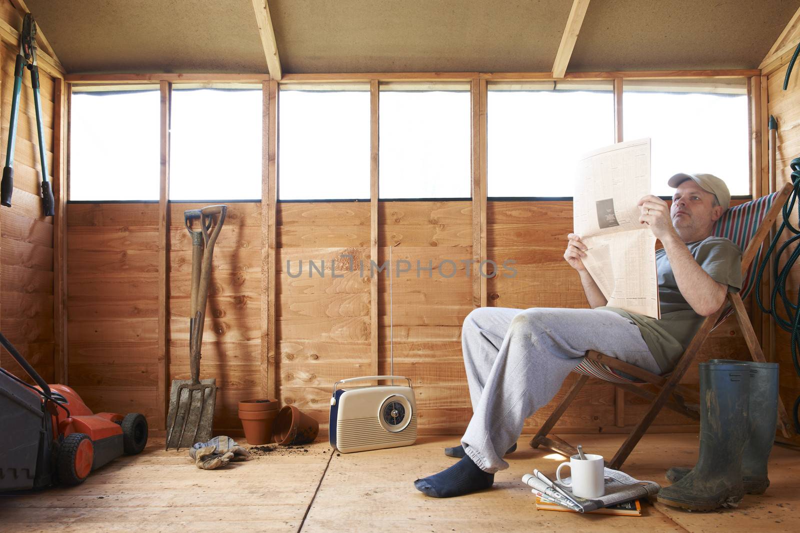 Man reading in garden shed by gemphotography